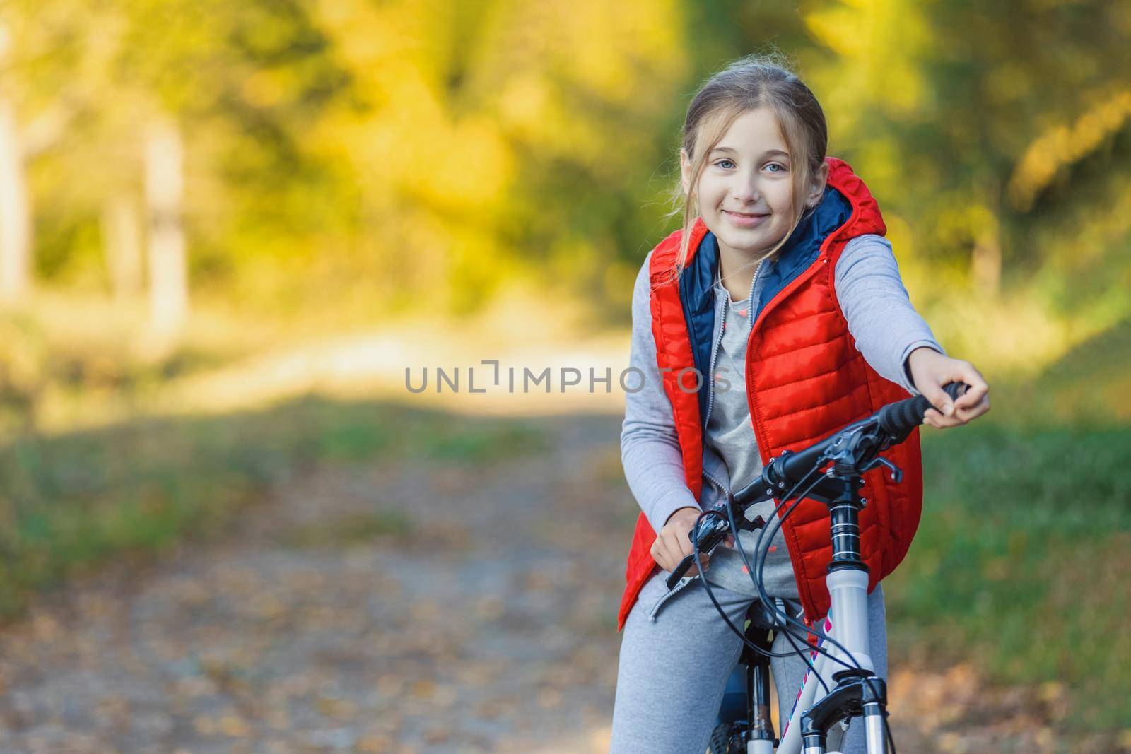 portrait of a girl with a bicycle on the background of an autumn forest