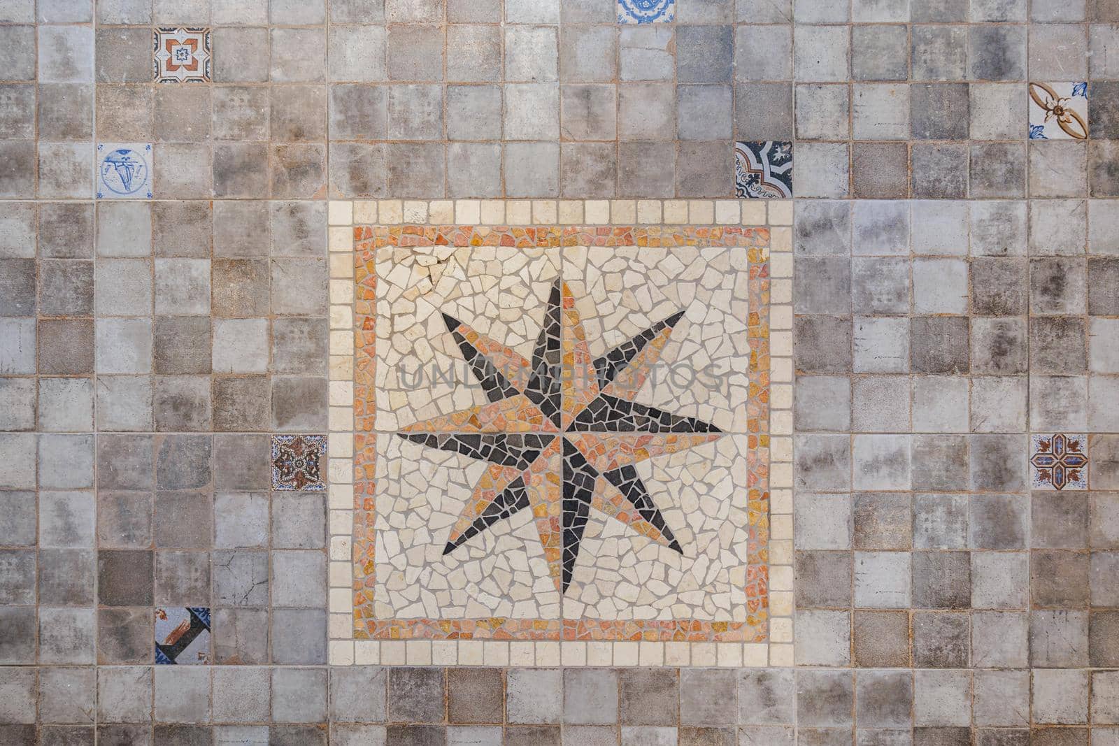Decorative gray floor tiles with big eight-pointed star in center placed in square.