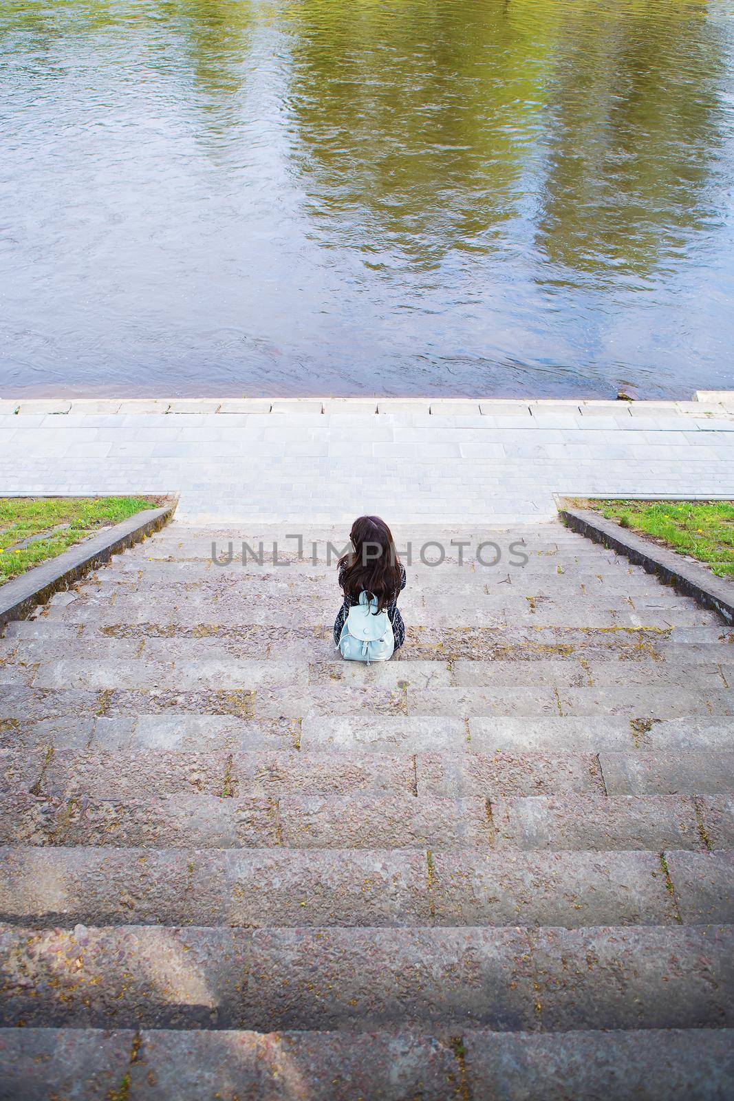 Beautiful girl sits and looks at the river Vilnius - Lithuania by sfinks