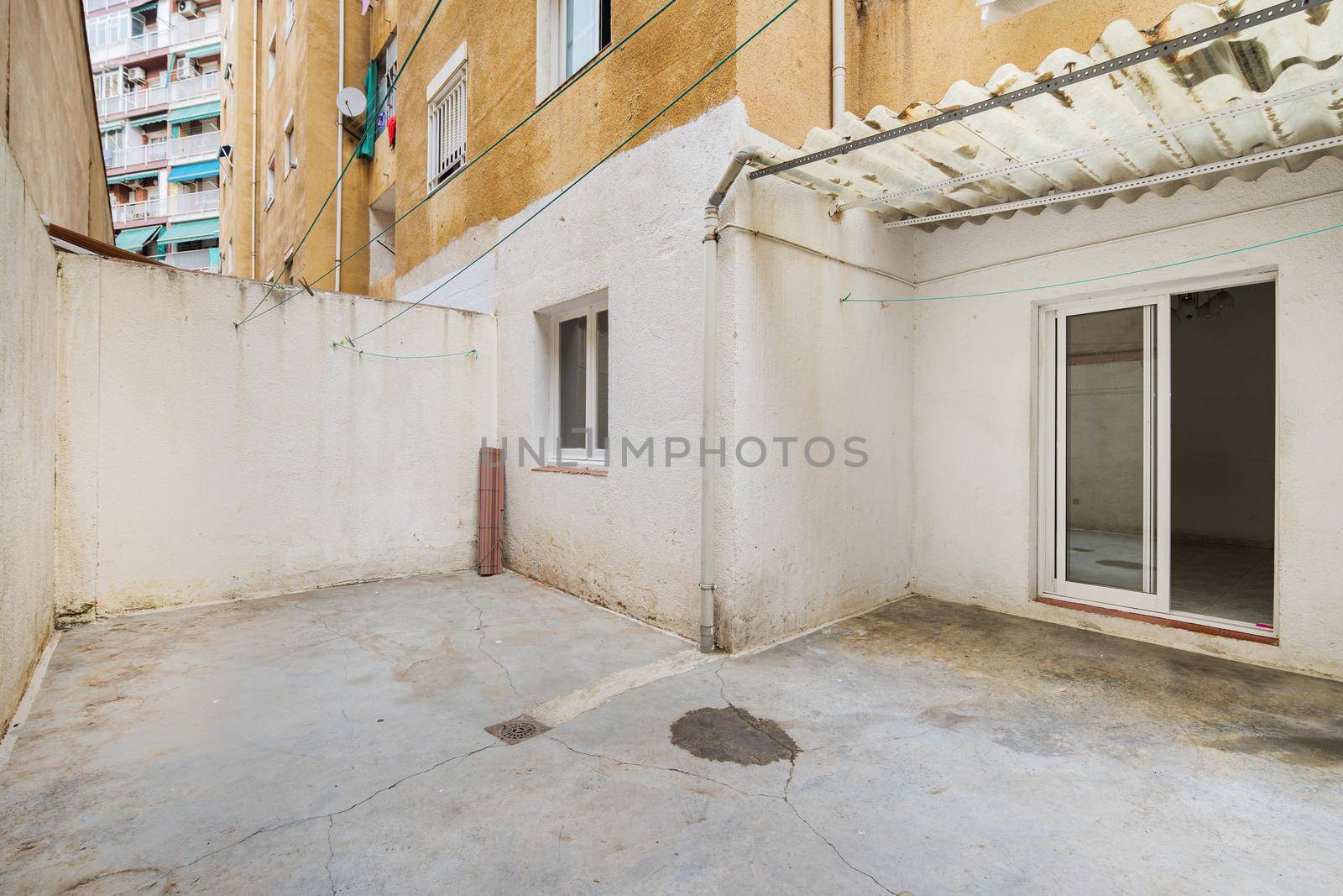 Empty and old patio of typical apartment in Barcelona. Worn out courtyard on lowest floor. by apavlin