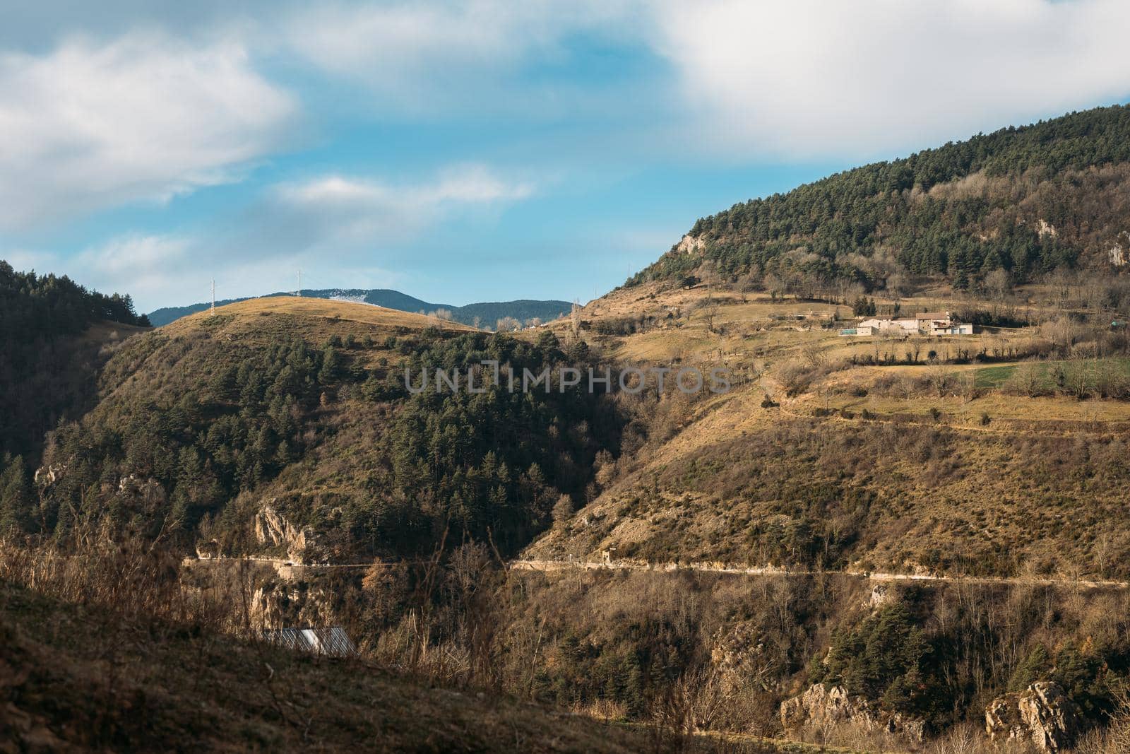 Beautiful rural landscape of mountainous area, few farm houses, blue sky with white clouds on sunny day in winter, countryside scenery in Spain by apavlin