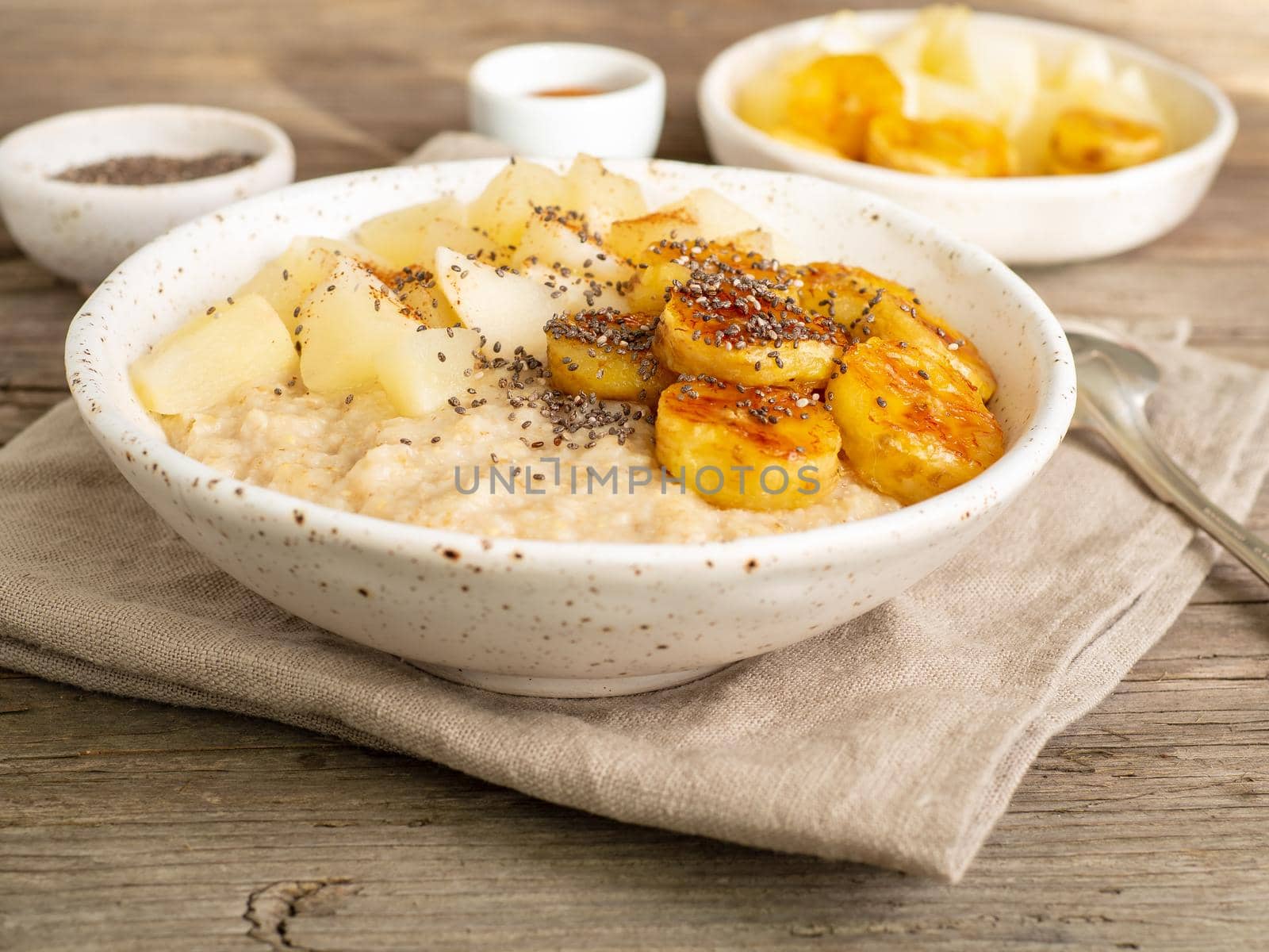 Large bowl of tasty and healthy oatmeal for Breakfast, morning meal. Top view, close up, wooden rustic table, sun light.