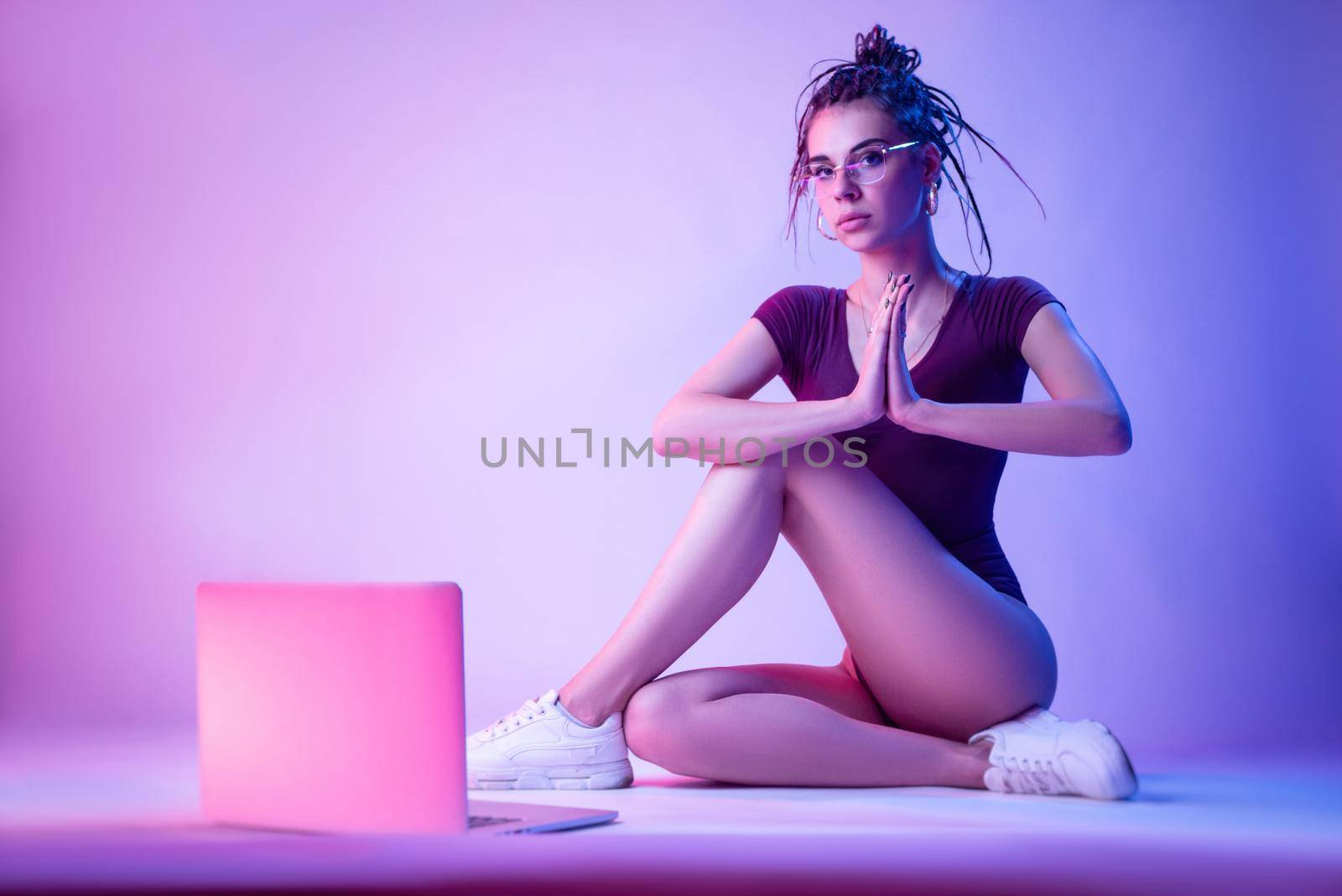 a girl with a laptop in neon light