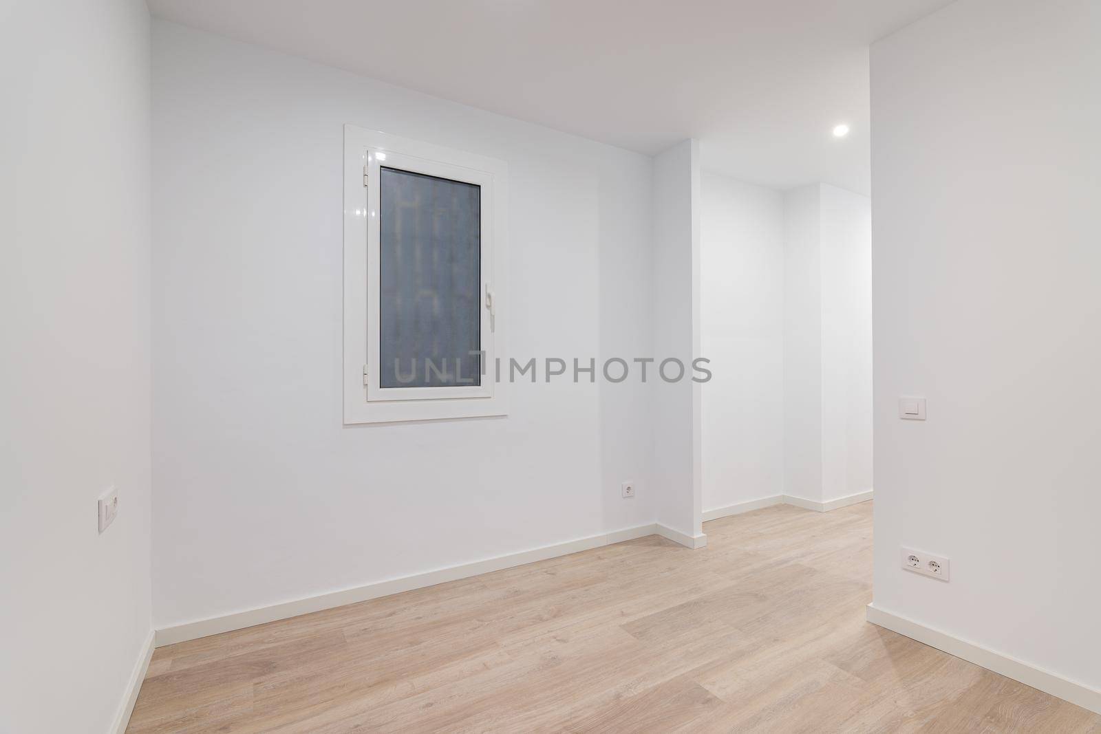 Empty white room with a window with a lattice. Modern apartment is after renovation