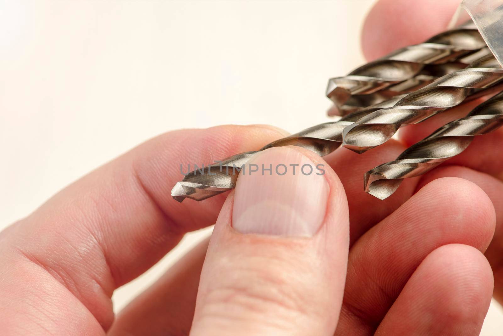 Installing a drill bit in a drill, hands take a drill and install it in a cordless drill chuck by SERSOL