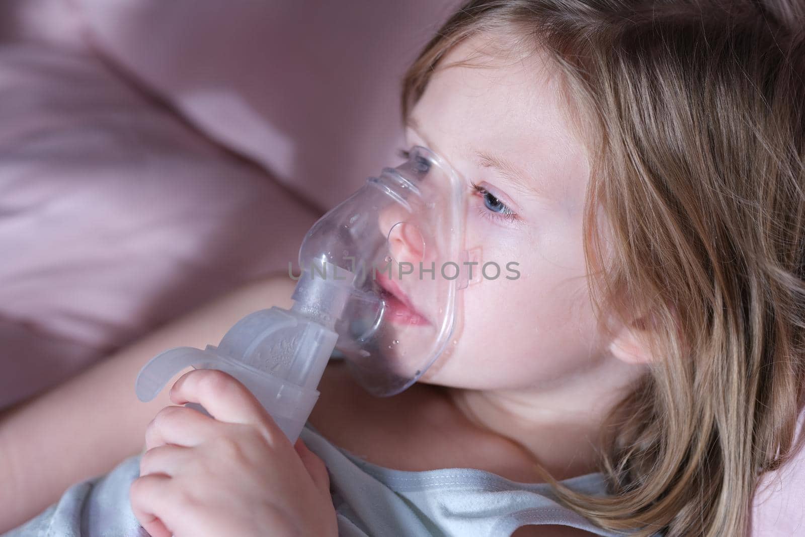 Portrait of sick little child in medical oxygen mask lying in bed. Labored breathing and lack of oxygen or inhalation concept