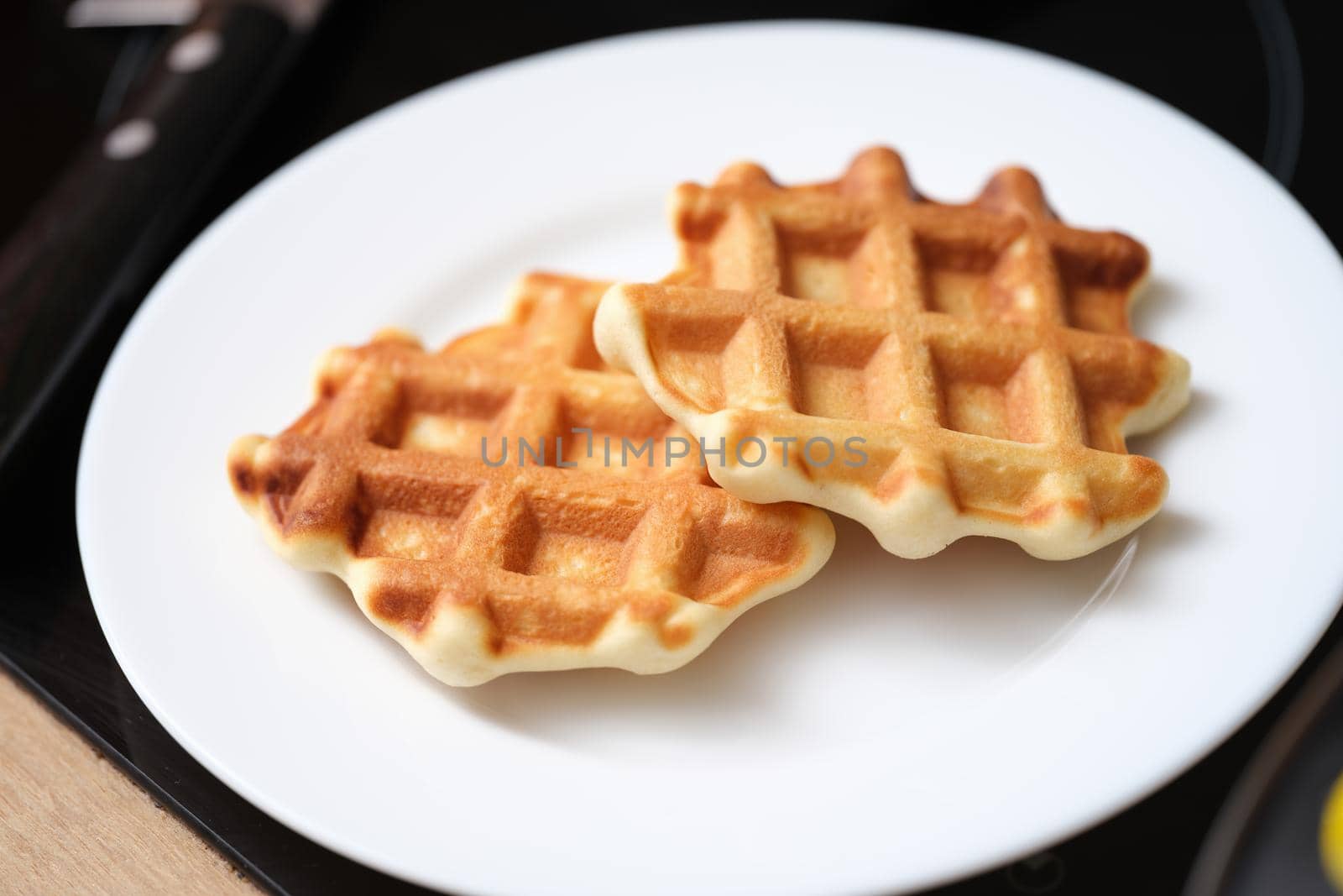 Close-up of delicious belgian waffles on white plate, yummy breakfast. Waffles of dutch, french and belgian foods