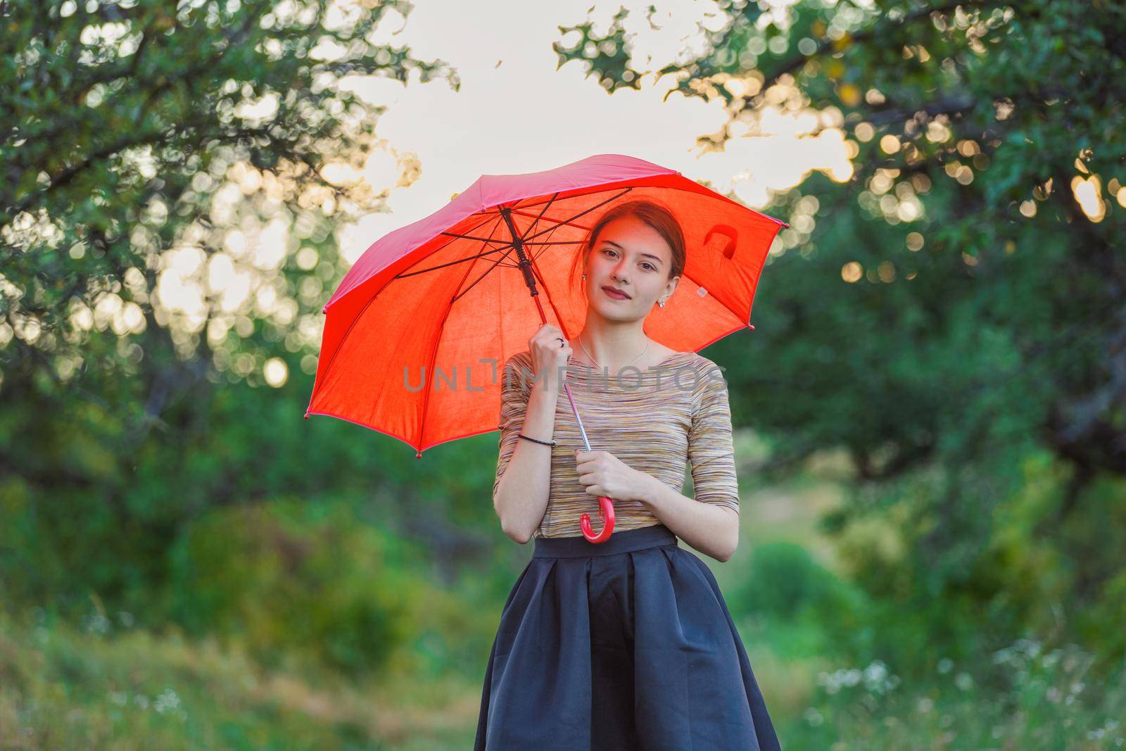 girl with a red umbrella in nature