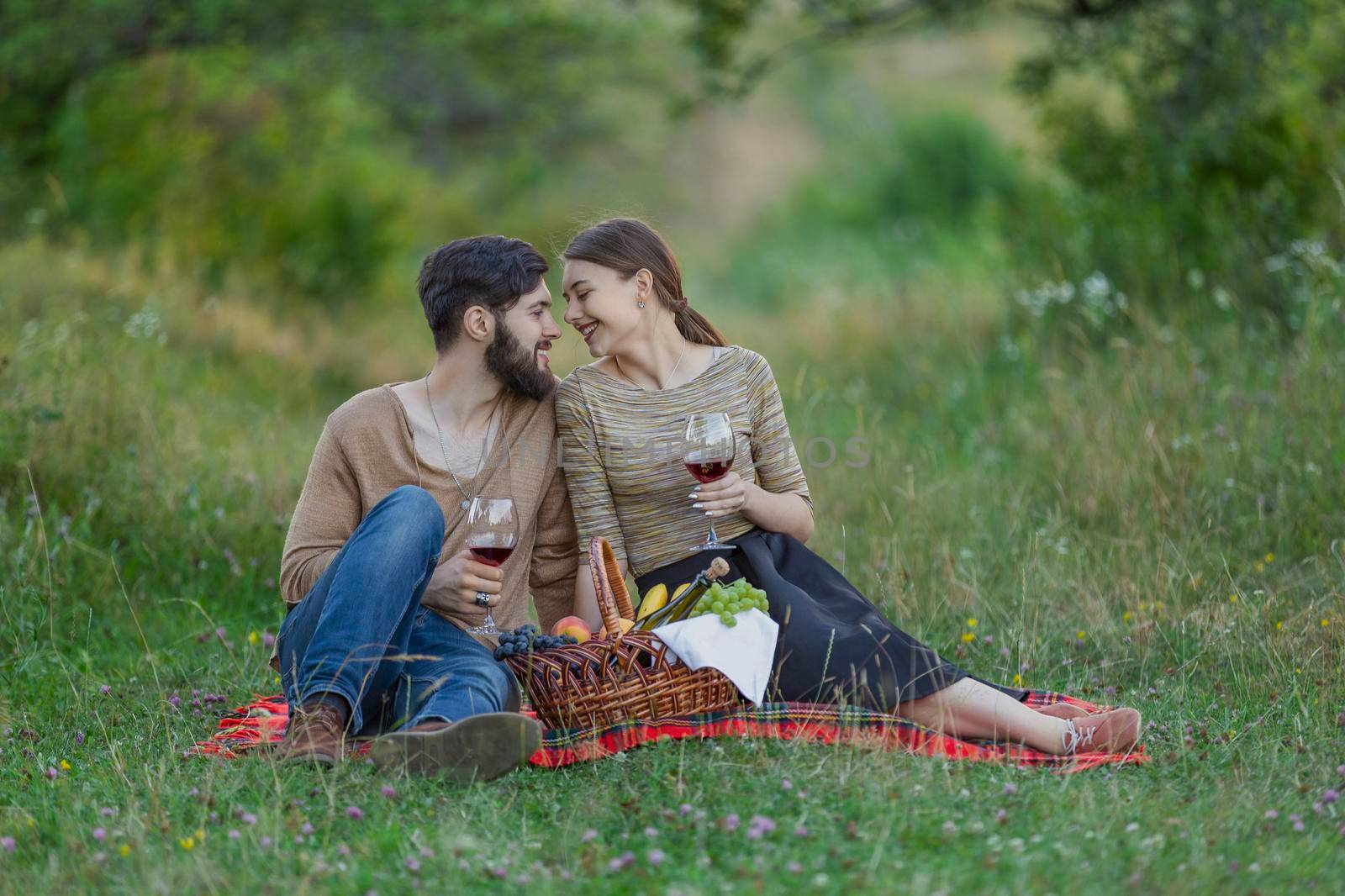 couple drinking wine from glasses in nature