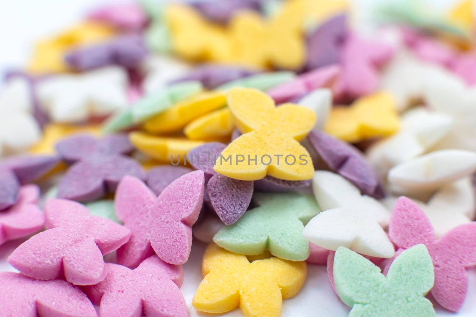 Colorful butterflies, pastel colored sugar confectionery sprinkles. Close-up. View from above