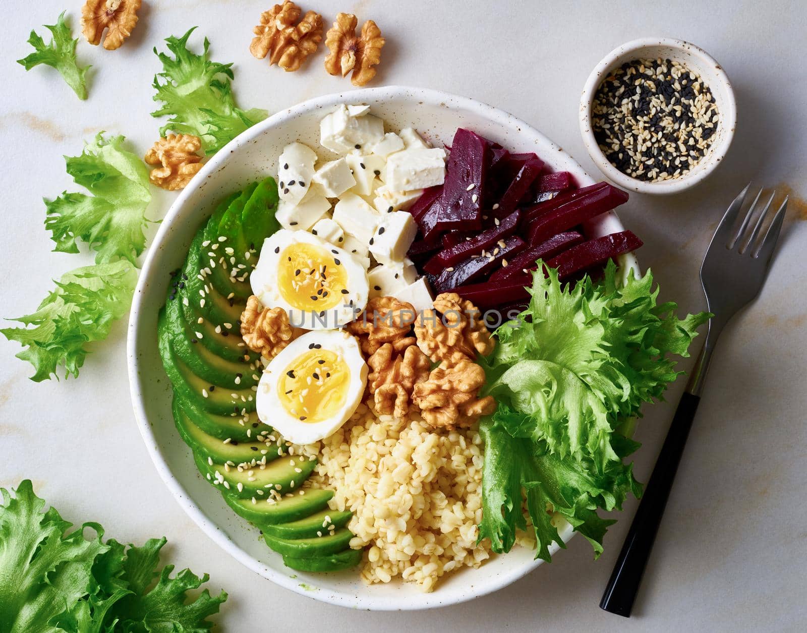 Buddha bowl, balanced food, vegetarian menu. Grey marble table, top view. Eggs, avocado, salad lettuce, bulgur, beetroot, tofu