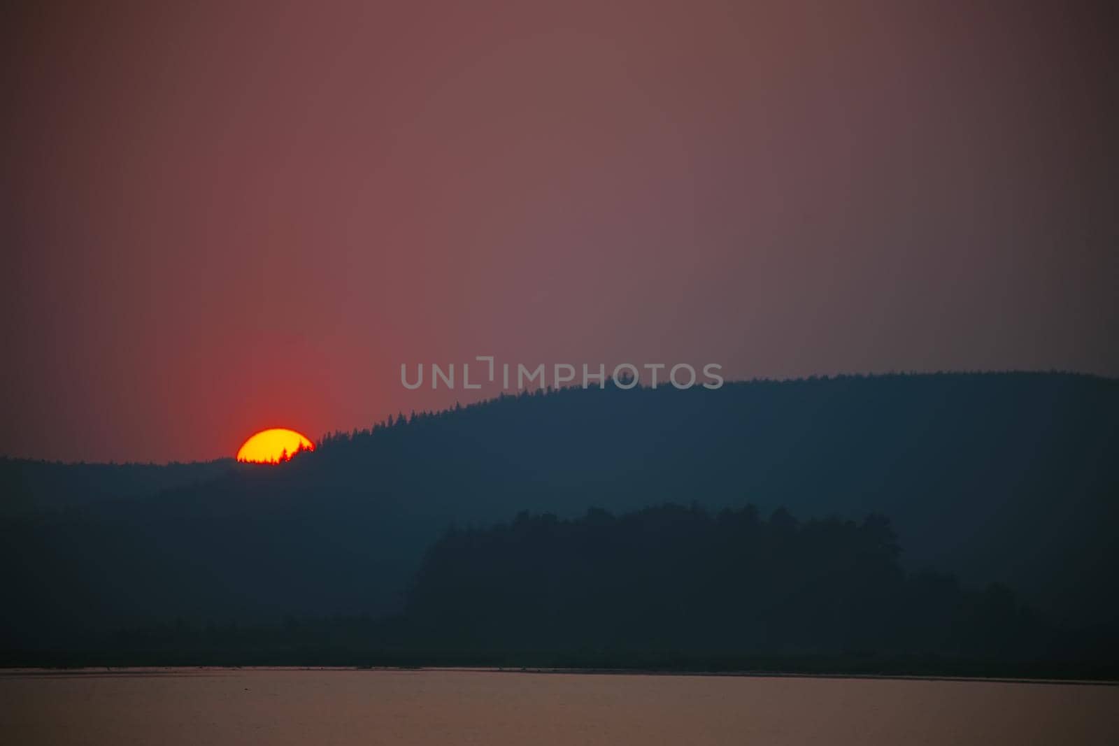 Sunset in the bay against mountainous background.