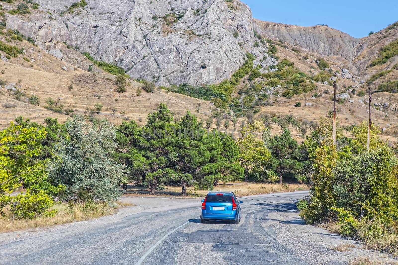 Car Moves along a winding road in the mountains during the day