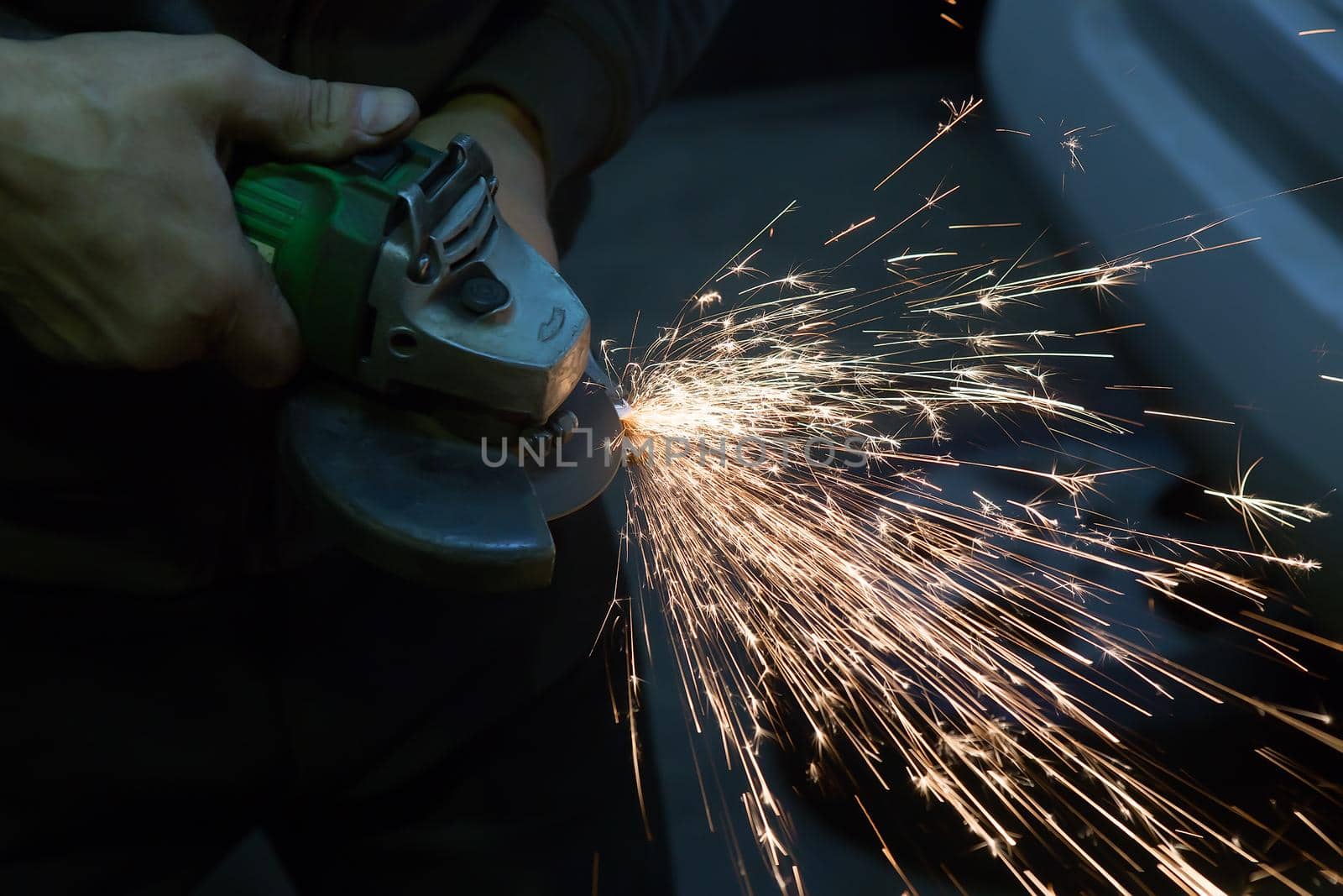 electric grinder in the hands of a man grinding metal
