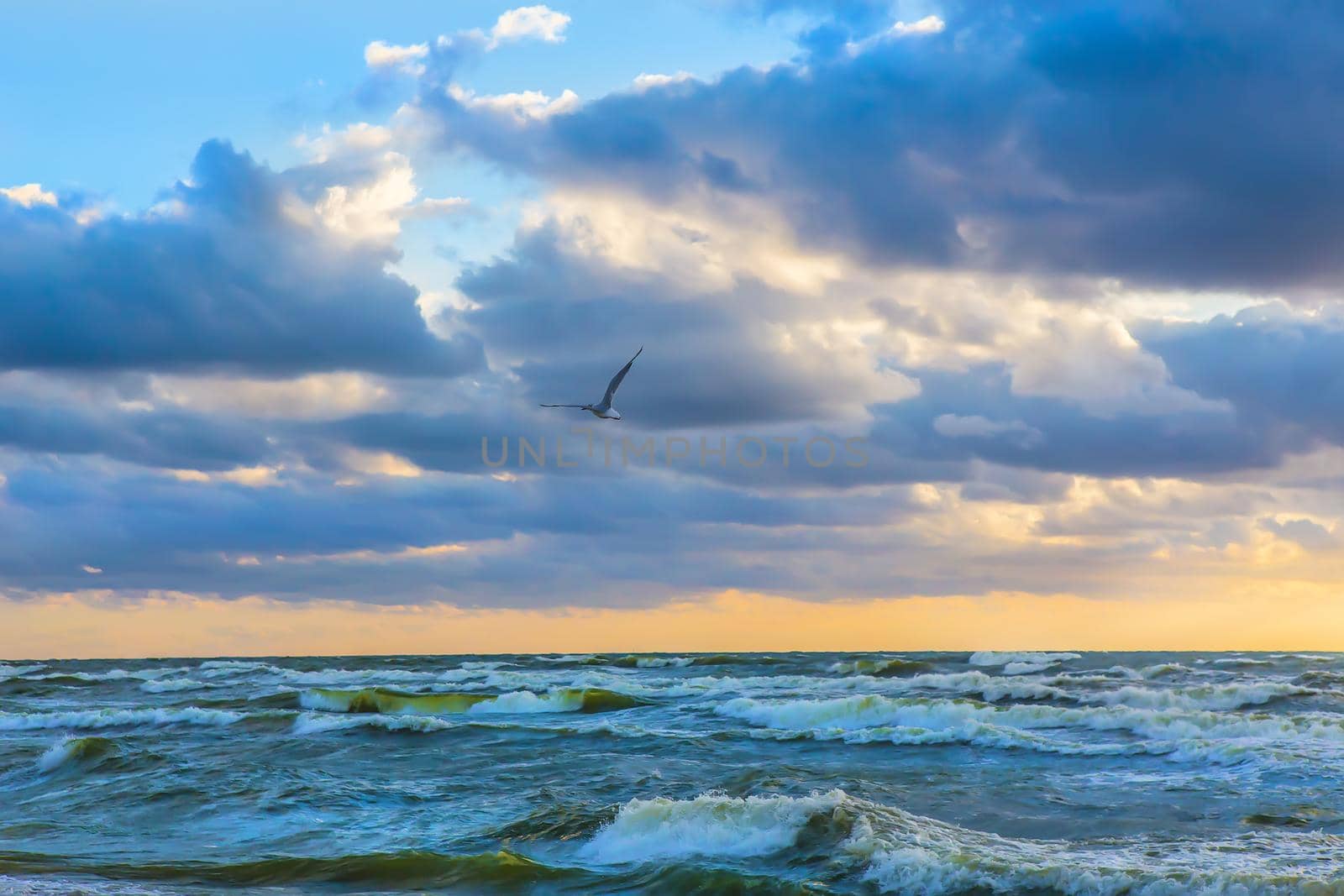 beautiful sunset in the cloudy sky above the stormy sea