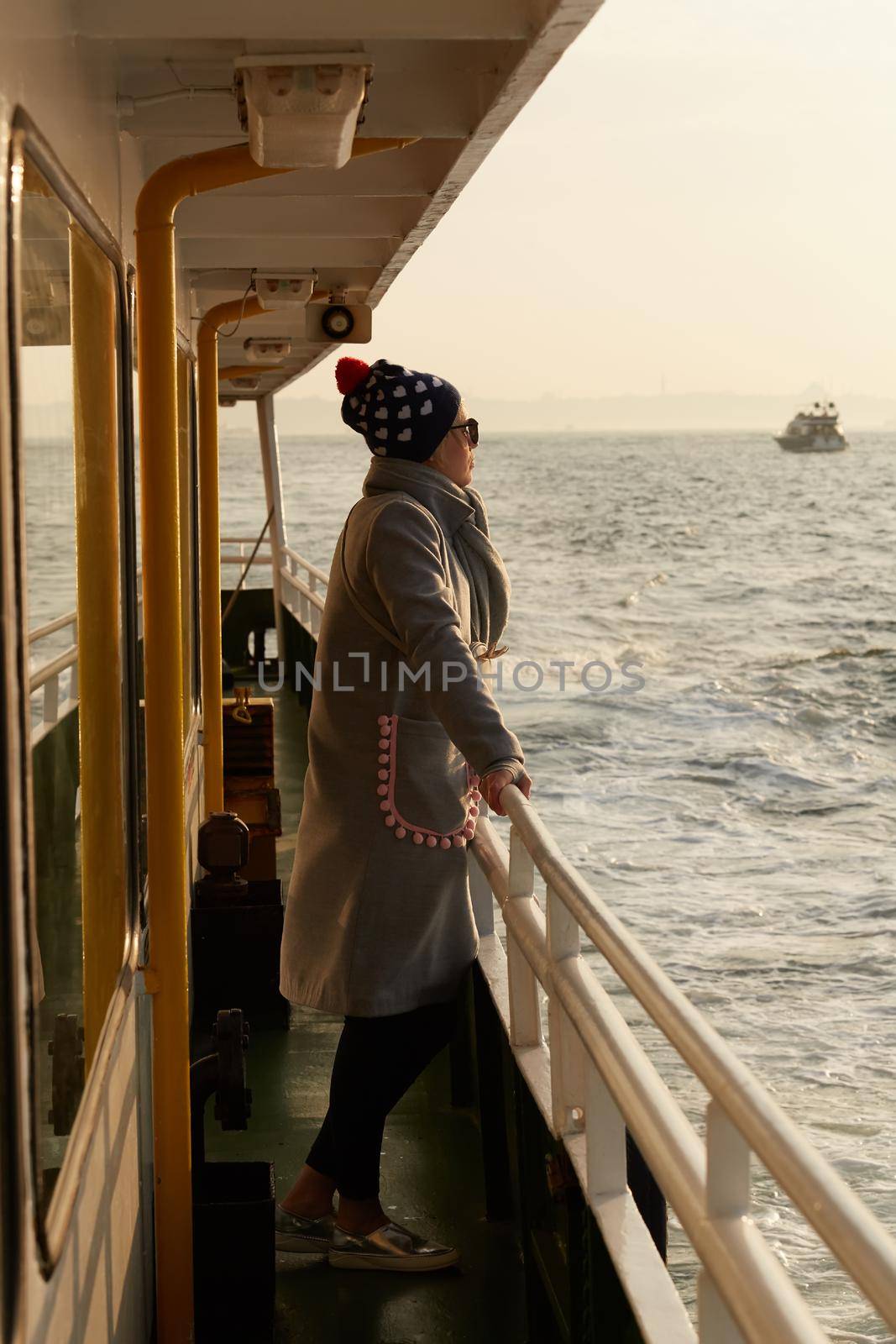 Woman traveling by boat at sunset among the islands. by sarymsakov