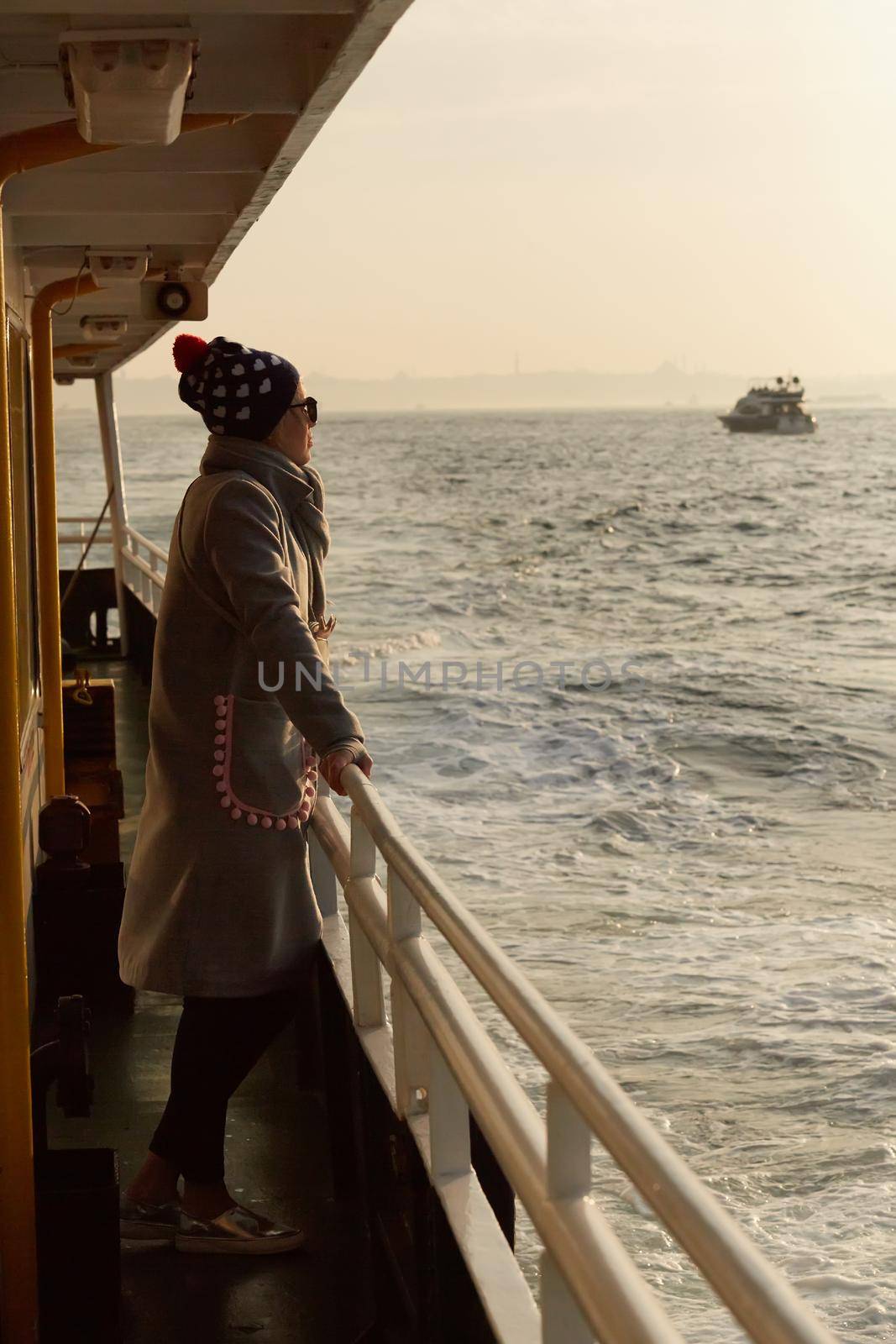 Woman traveling by boat at sunset among the islands. by sarymsakov