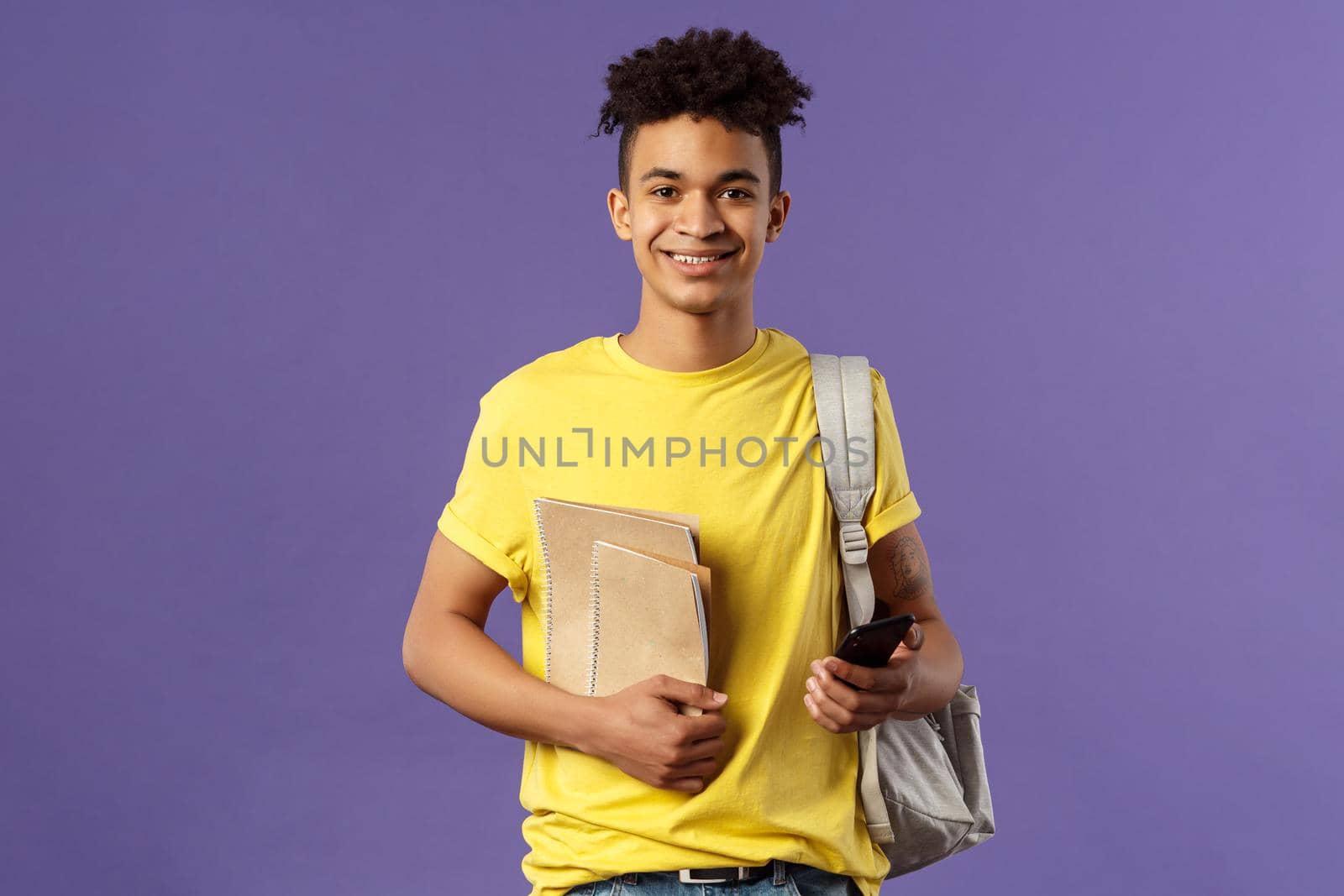 Back to school, university concept. Portrait of young cheerful male student with dreads, hipster going to his campus, carry backpack and study material, notebooks, purple background by Benzoix