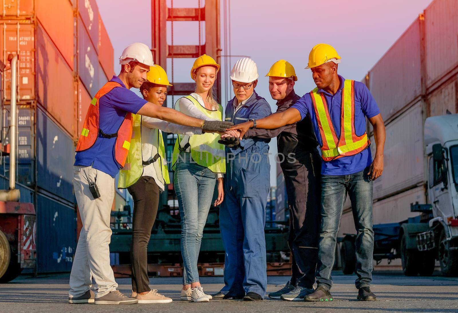 Group of man and woman in cargo container area join hands together in the concept of best collaborate for working. by nrradmin