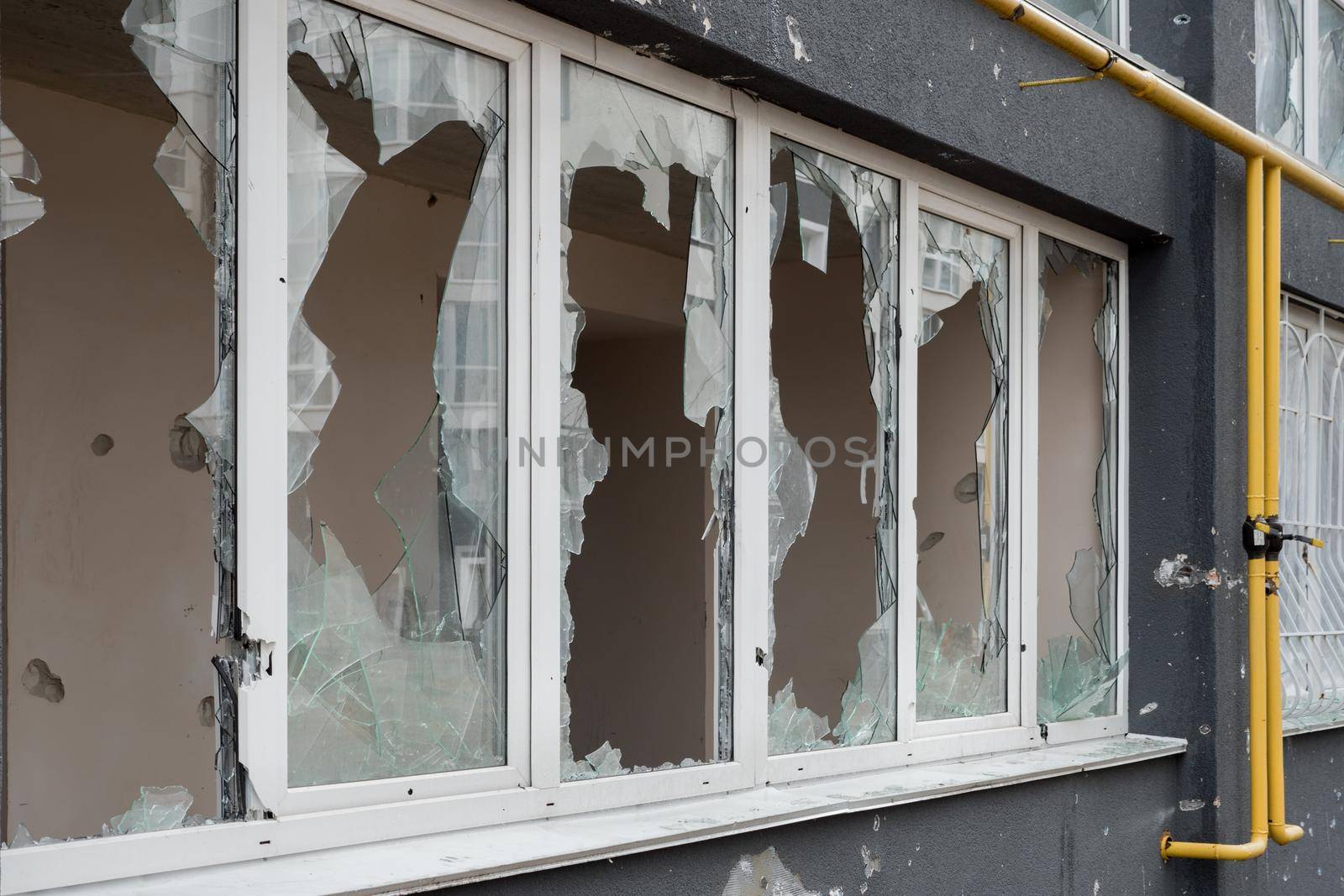 Aftermath bombed building window shatter glass damage building destruction Ukraine war Russia shooting civilian shell. Smashed window broken glass break. Destroyed building broken frame window plastic by synel