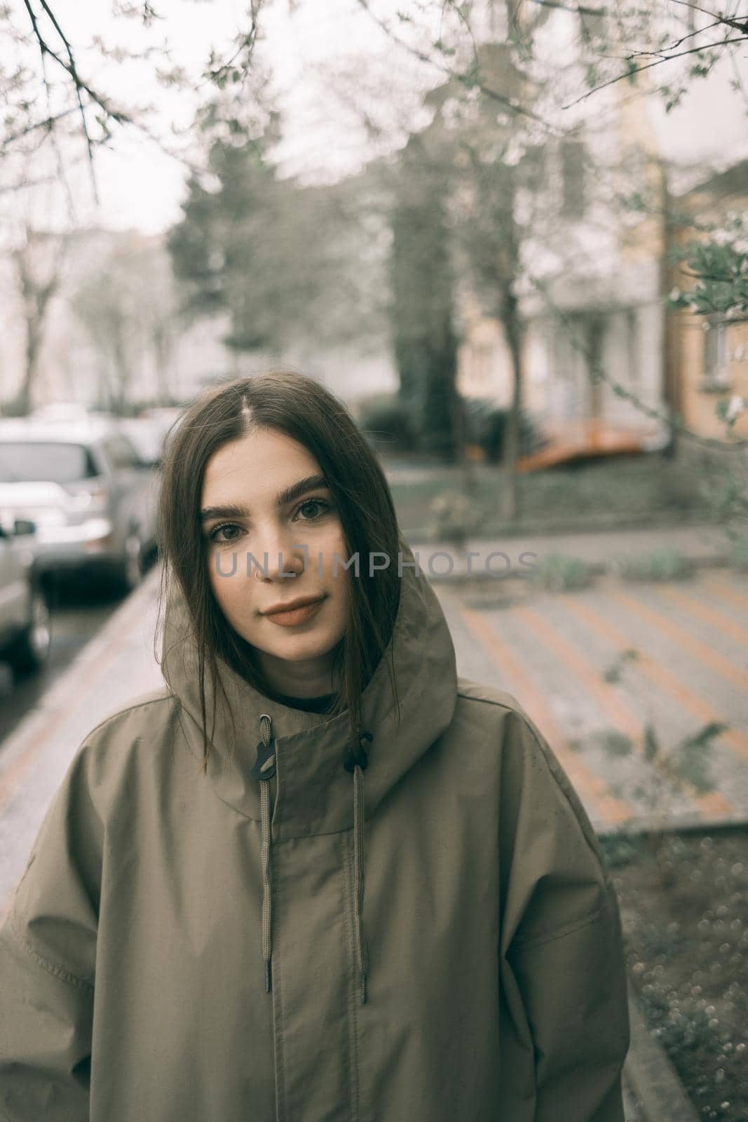 beautiful girl in a raincoat on street