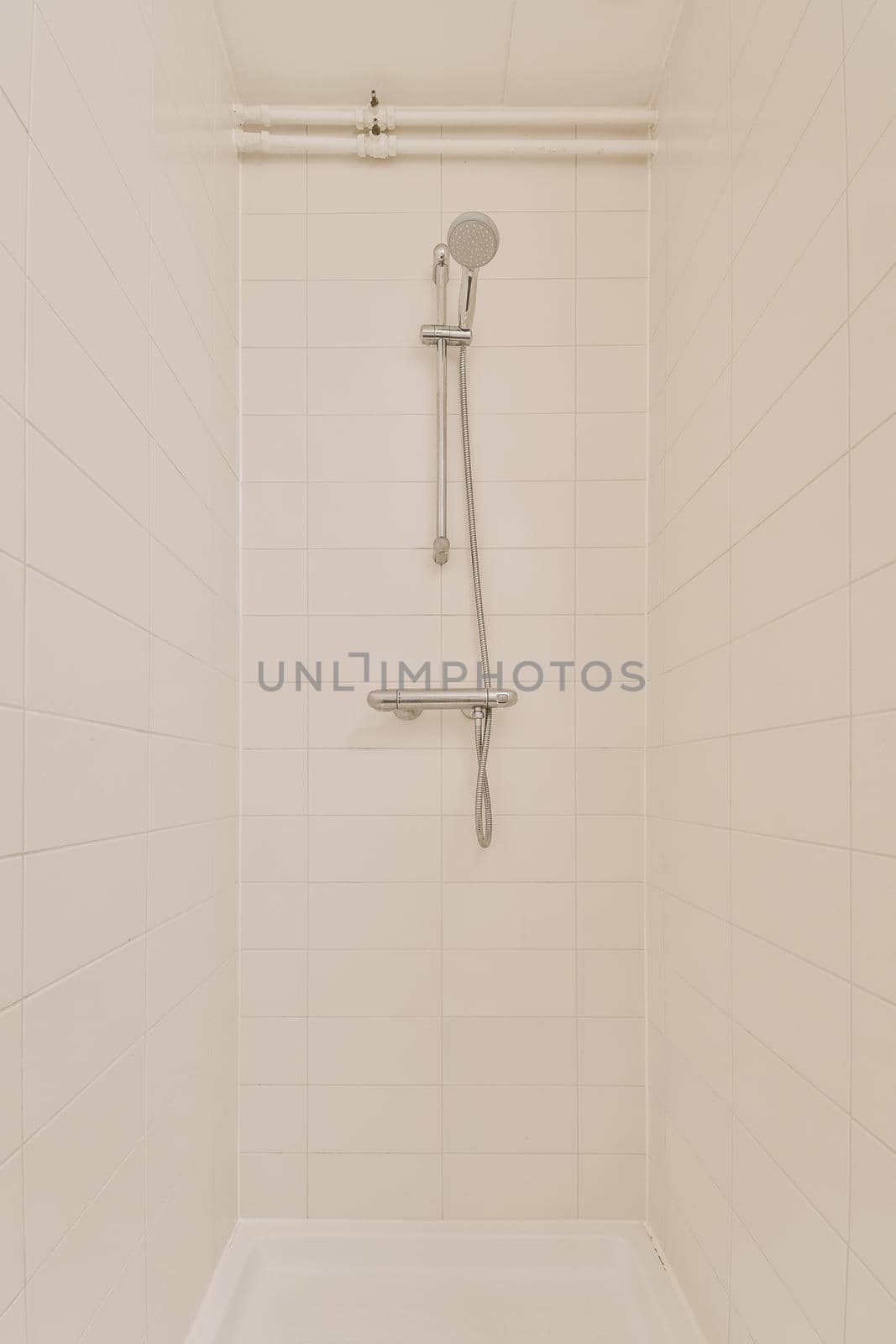 View of the bathroom with shower surrounded by white tiles by casamedia