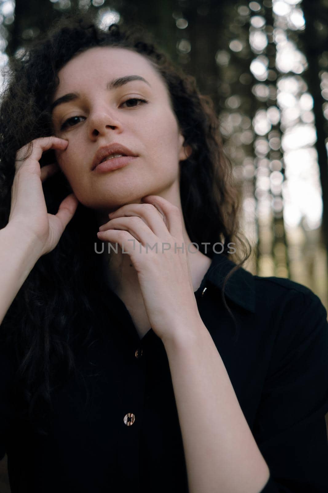 portrait of curly brunette woman in the park close up by Symonenko