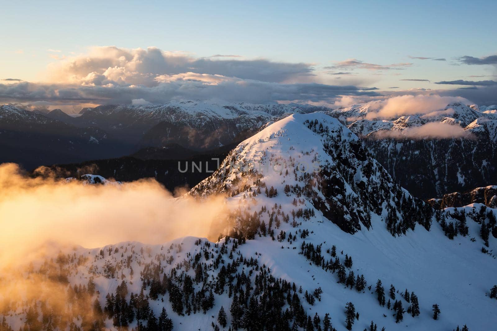 Aerial Landscape View of Coquitlam Mountain during a colorful cloudy sunset. Taken in Vancouver, British Columbia, Canada.