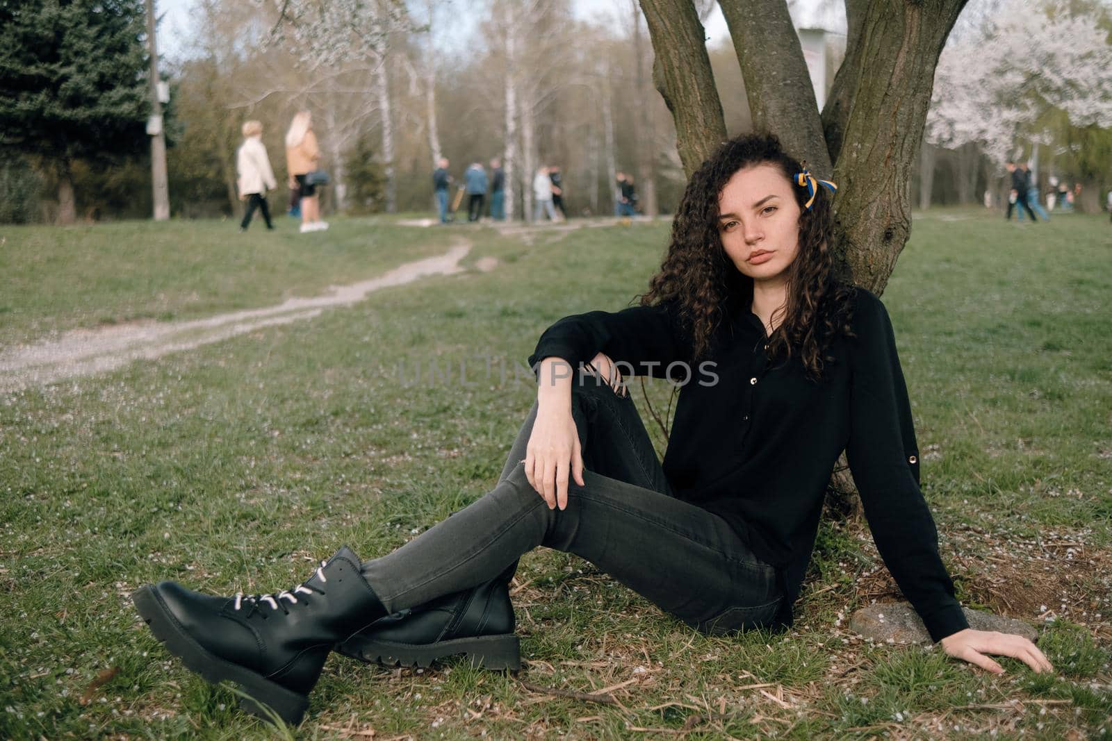 portrait of curly brunette woman in red coat in the park by Symonenko