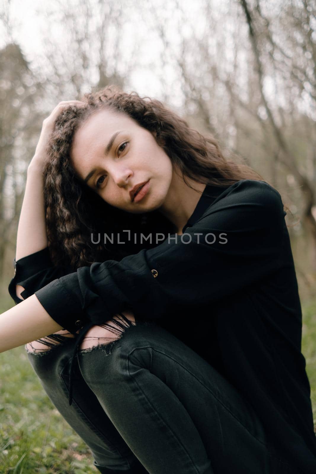 portrait of curly brunette woman in the park by Symonenko