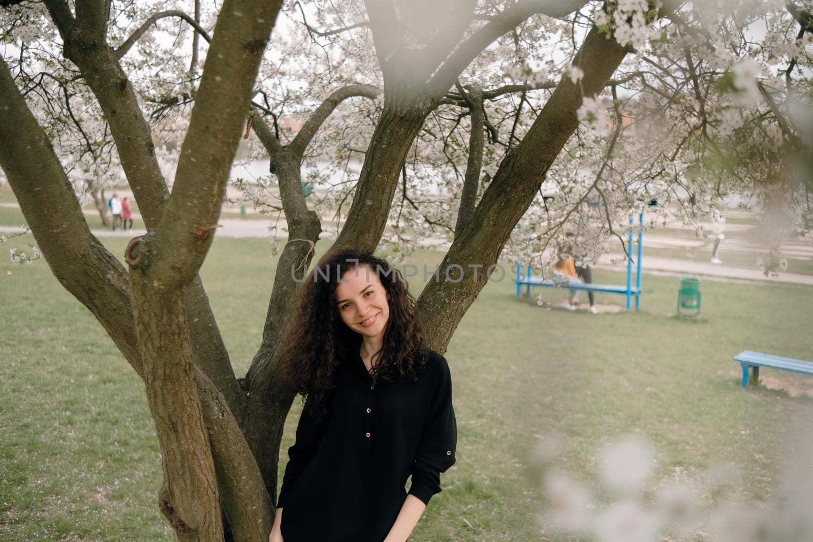 portrait of curly brunette woman in red coat in the park