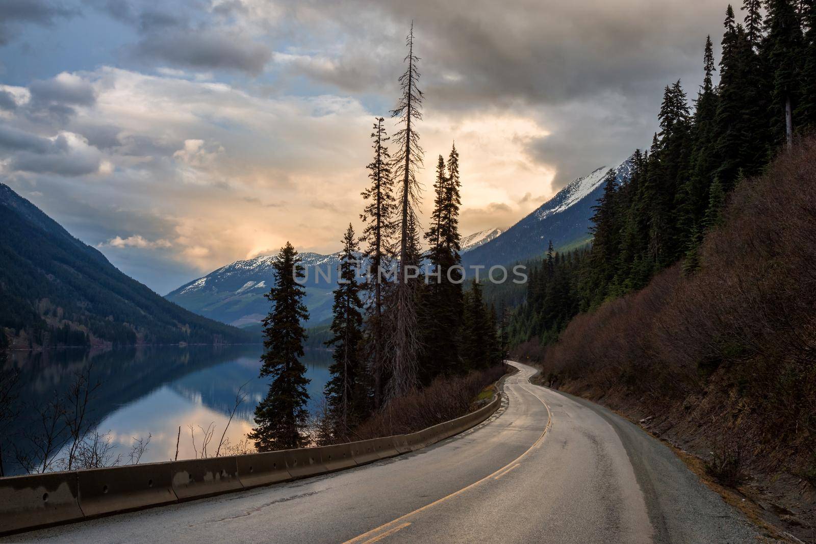 Scenic road by the lake and mountains during a cloudy sunset by edb3_16