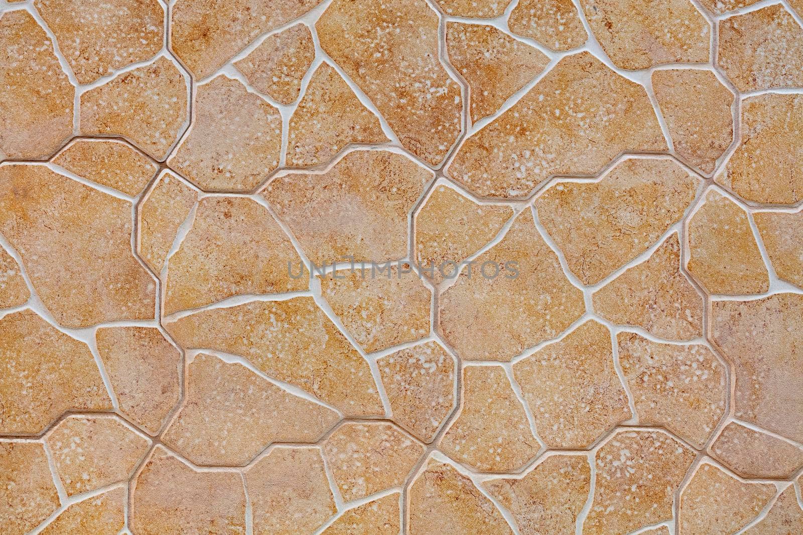 The texture and background of the wall is made of stone tiles of beige-golden limestone in the form of masonry.