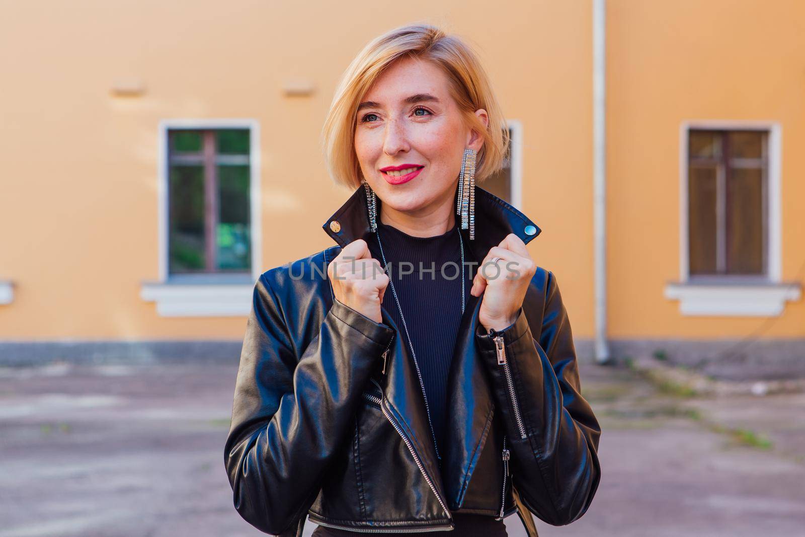 Street fashion concept - closeup portrait of a pretty girl wearing leather jacket outdoors.