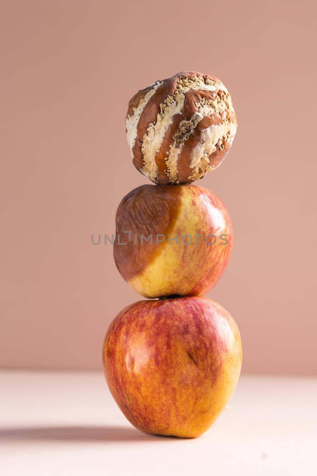 Apple with mold and fresh apple on beige background - mold growth and food spoilage concept. Copy space and place for advertising. High quality photo