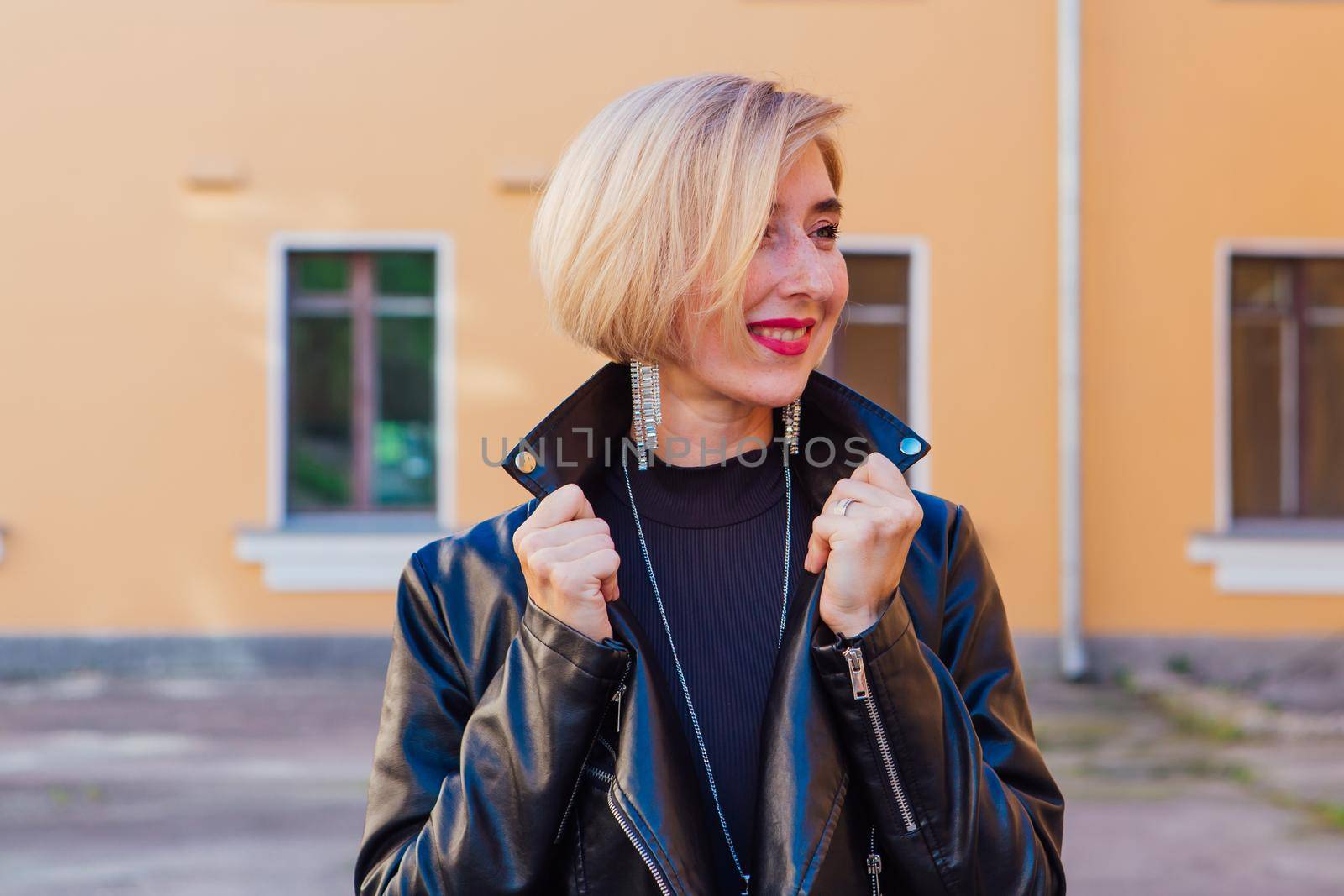 Street fashion concept - closeup portrait of a pretty girl wearing leather jacket outdoors.