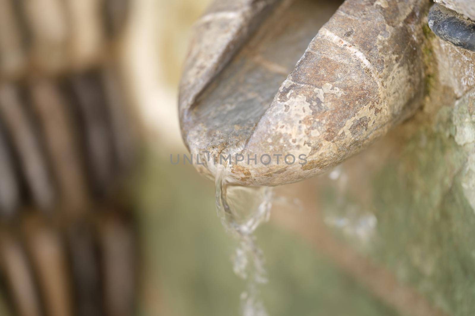 Close-up of water source in mountain, spring water or well-water with stone channel. Unpolluted natural well-water concept