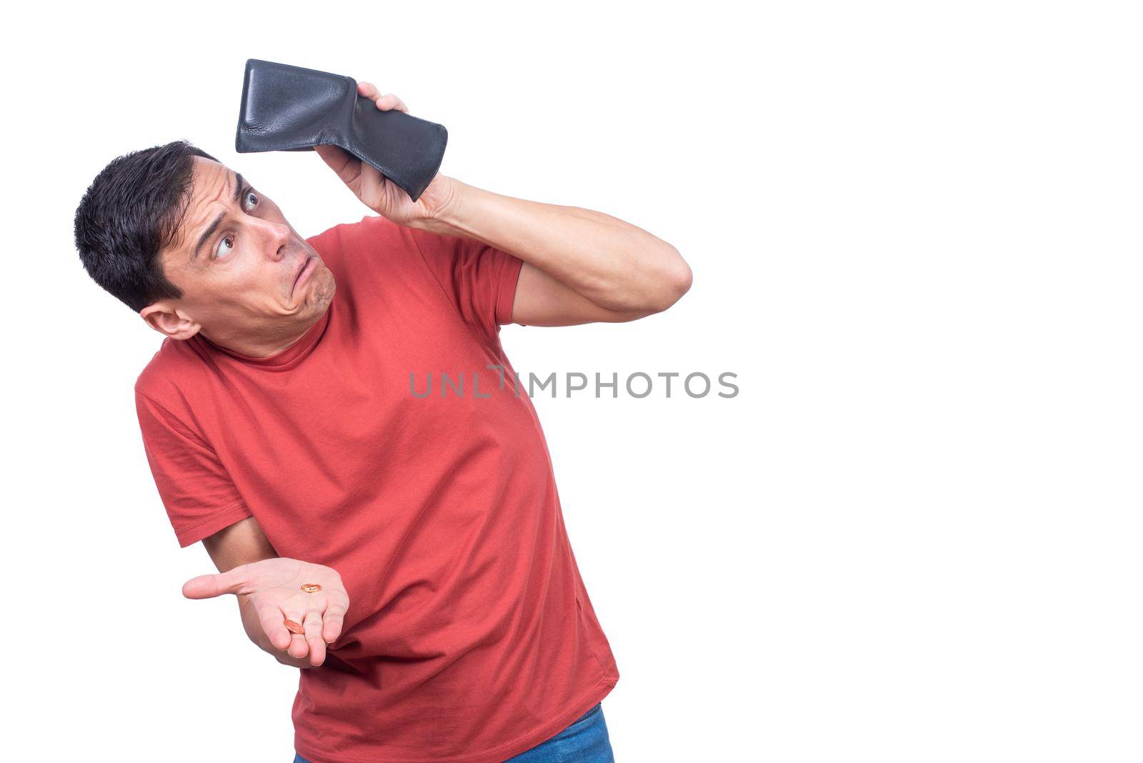 Shocked man in red t shirt looking at wallet with no money in hand isolated on white background