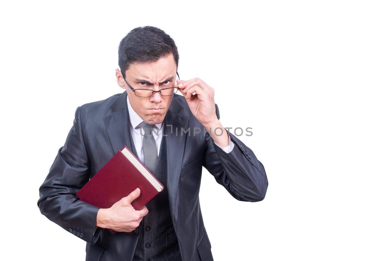 Irritated male teacher in formal wear and eyeglasses with book looking at camera while standing isolated on white background in studio