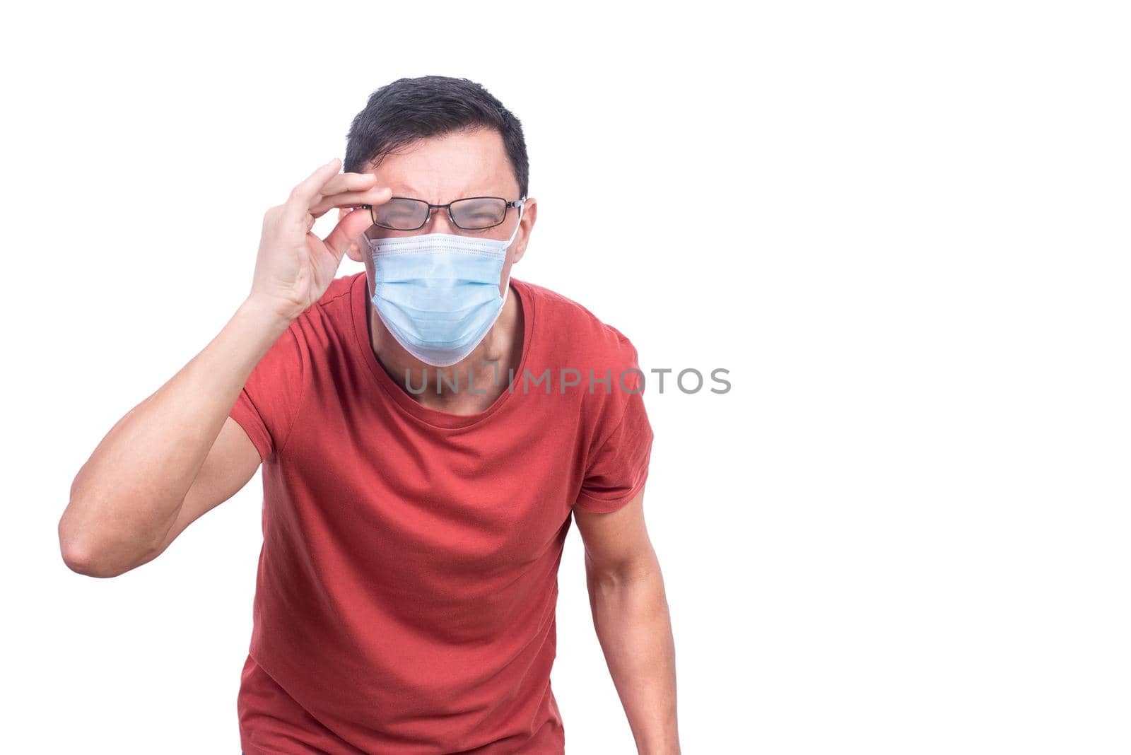 Male in protective mask looking at camera through fogged up eyeglasses while standing isolated on white background during coronavirus pandemic