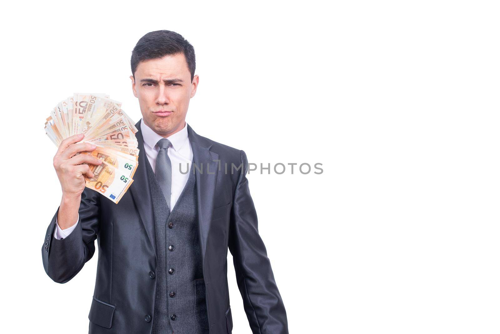 Successful rich male businessman with bunch of money looking at camera while standing isolated on white background in light studio
