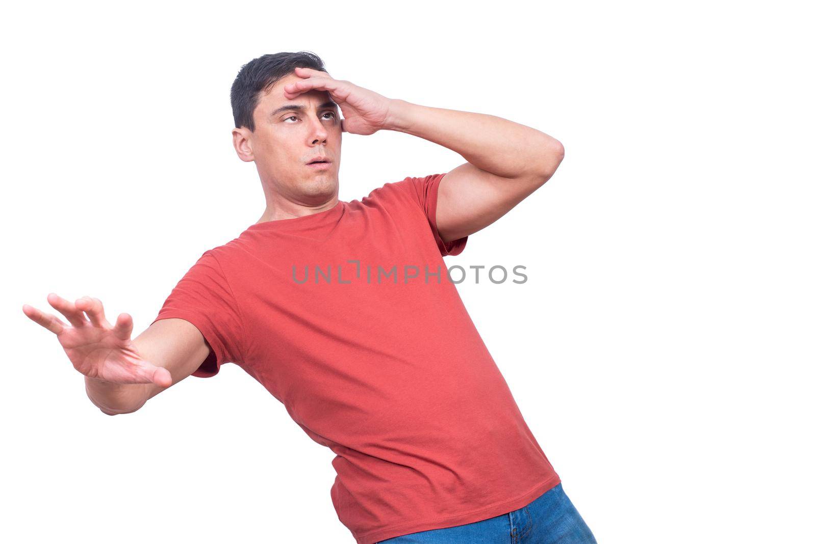 Guy in red t shirt touching forehead and waving arm during severe fainting against white background in studio