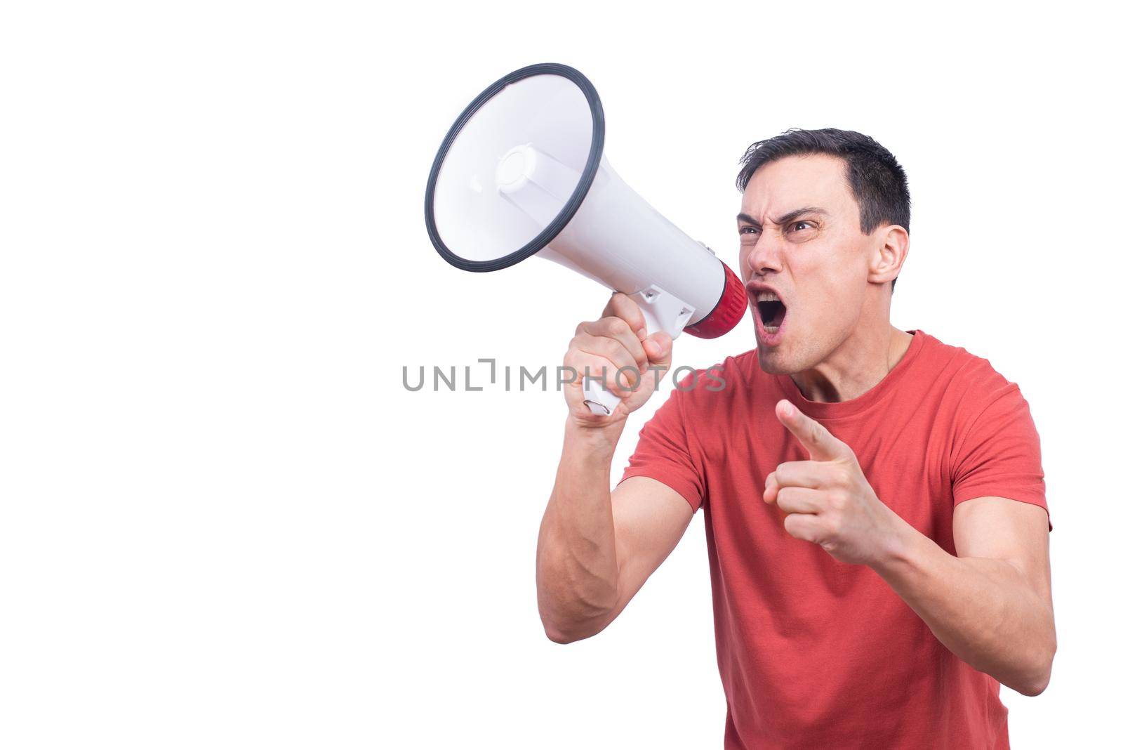 Excited male yelling in megaphone and pointing away with finger on white backdrop in studio