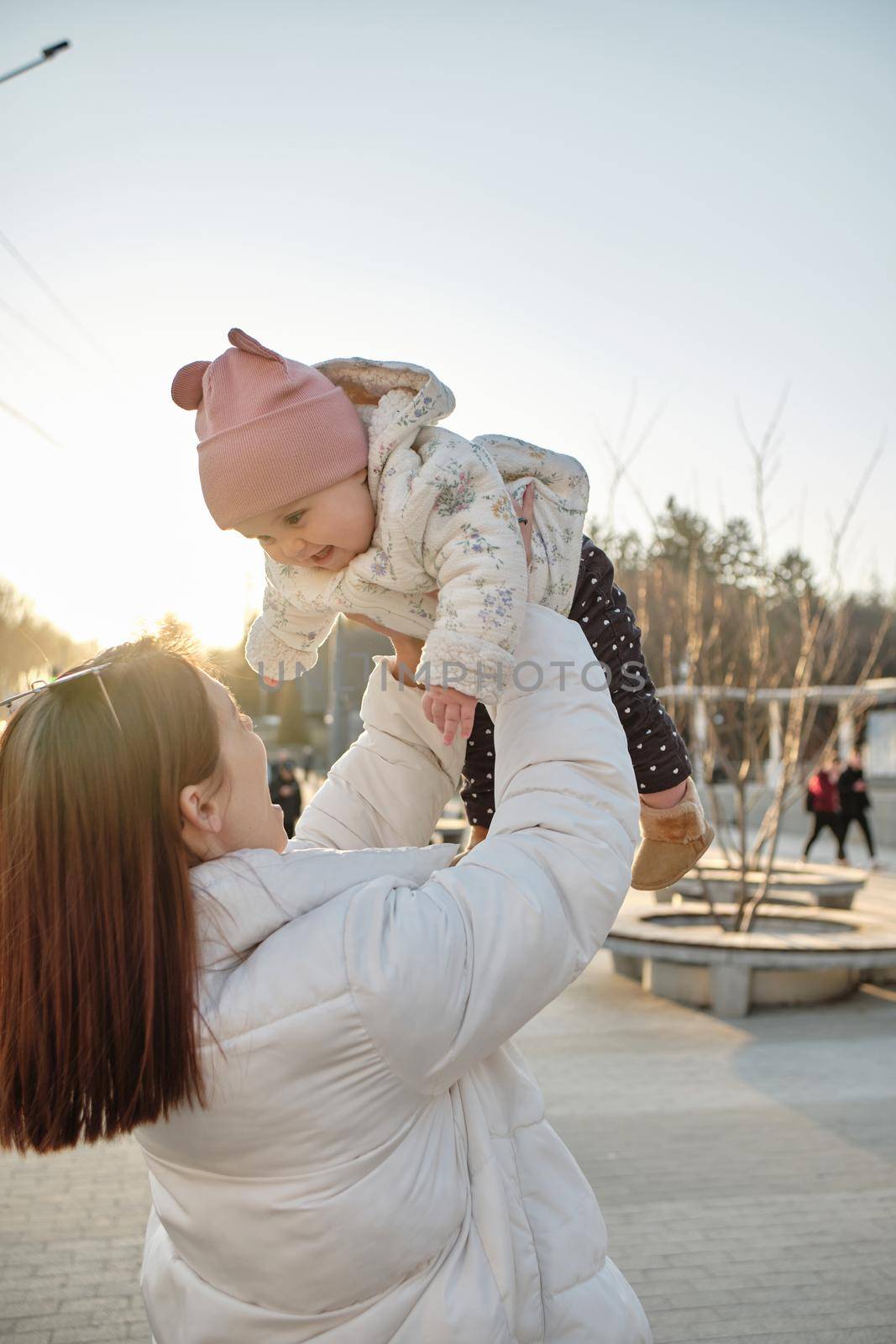 happy harmonious family outdoors. mother throws baby up, laughing and playing in the summer on the nature