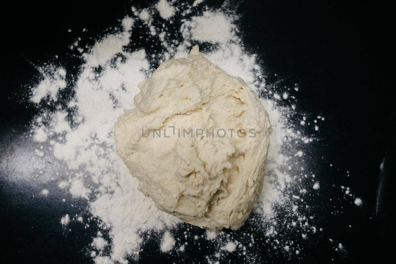 Raw dough on a black table with side light dark