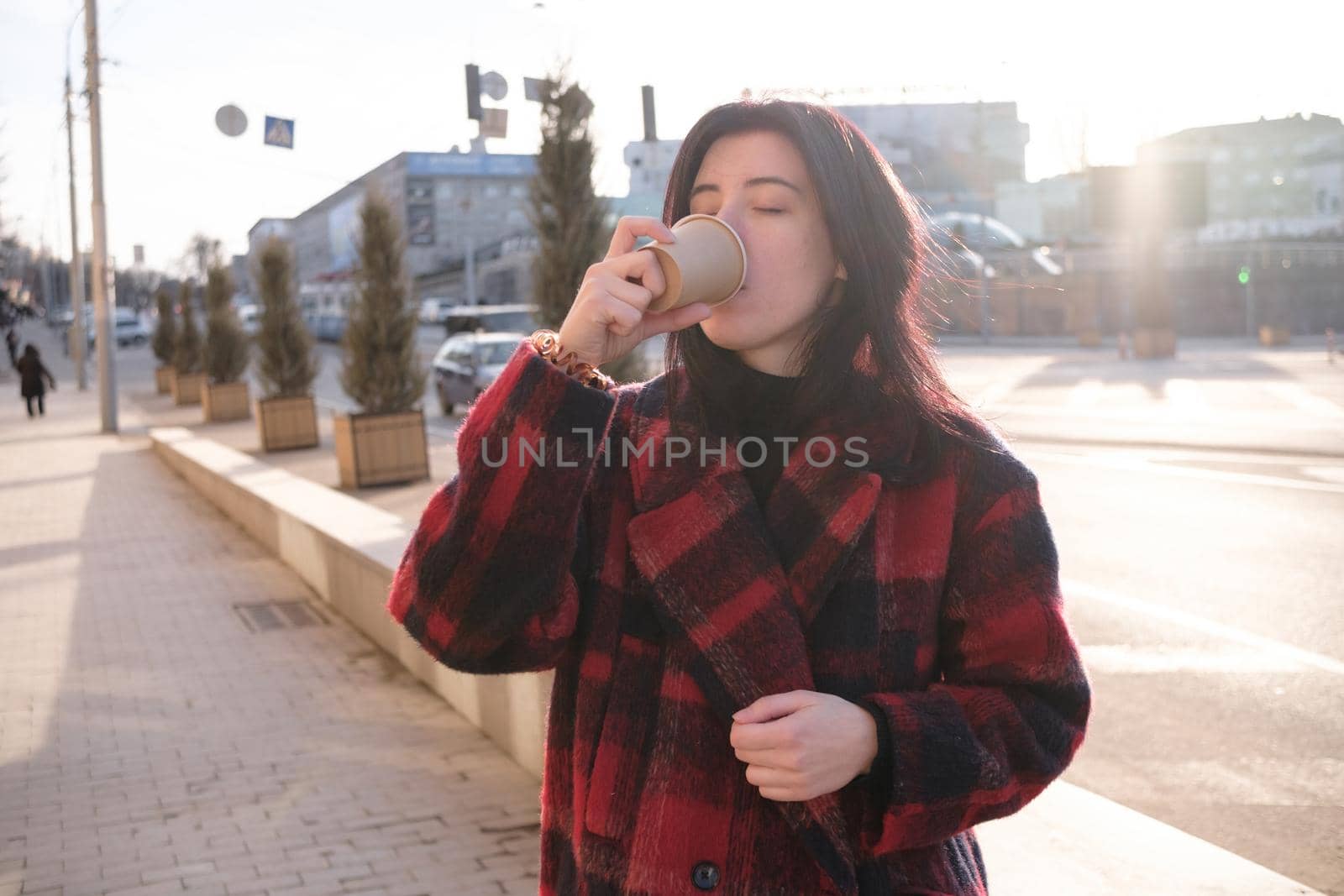 Woman drinking coffee in the sun, outdoor in sunlight light, enjoying her morning