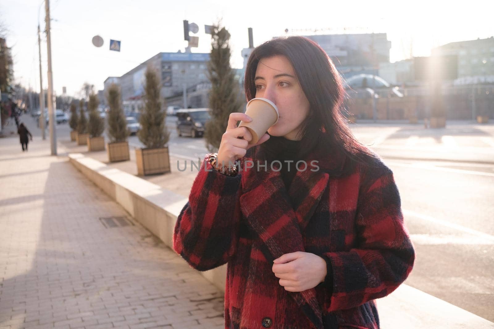 Woman drinking coffee in the sun, outdoor in sunlight light, enjoying her morning