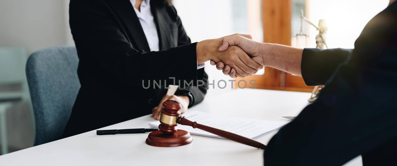 Businessman shaking hands to seal a deal Judges male lawyers Consultation legal services Consulting in regard to the various contracts to plan the case in court by nateemee