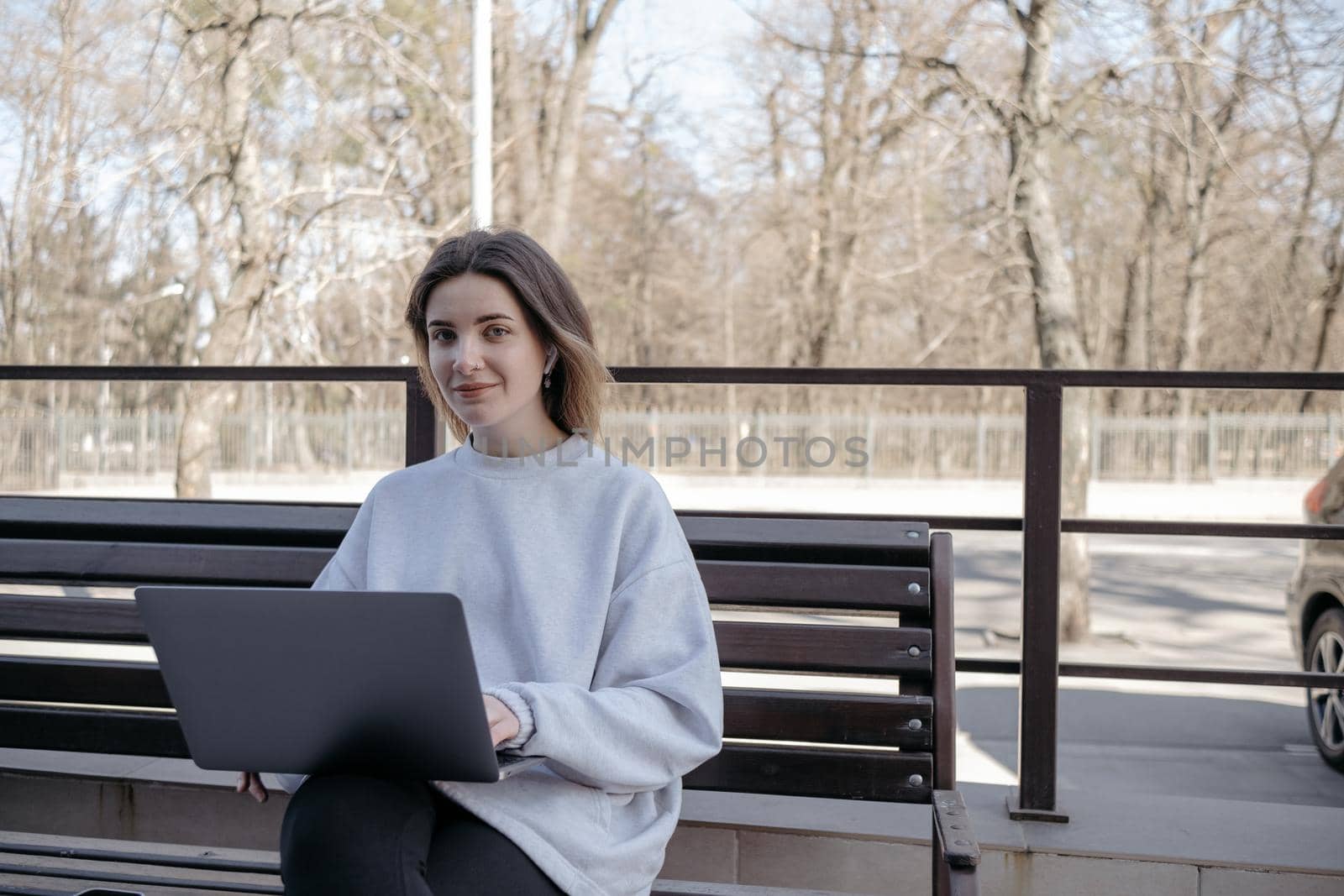 Photo of funky adorable young woman sit near fountain break from work look laptop drink coffee wear pants shirt top bag in park outdoors