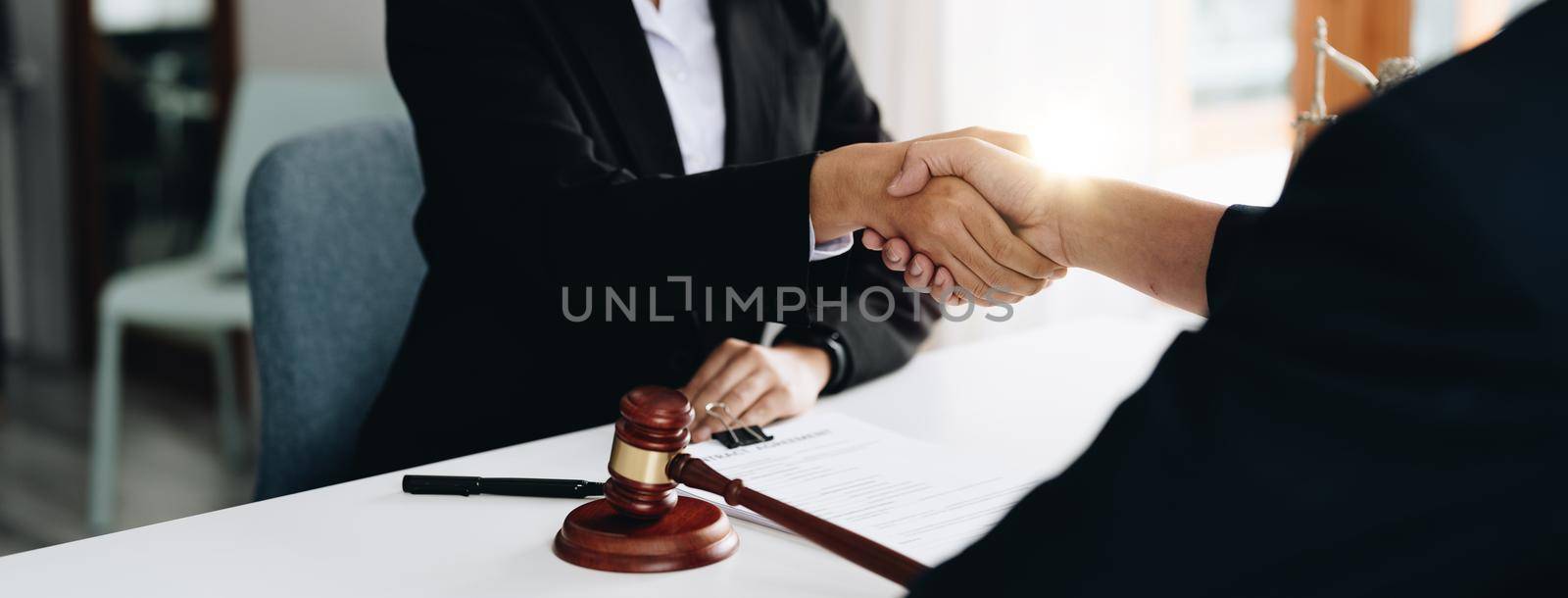 Businessman shaking hands to seal a deal Judges male lawyers Consultation legal services Consulting in regard to the various contracts to plan the case in court by nateemee